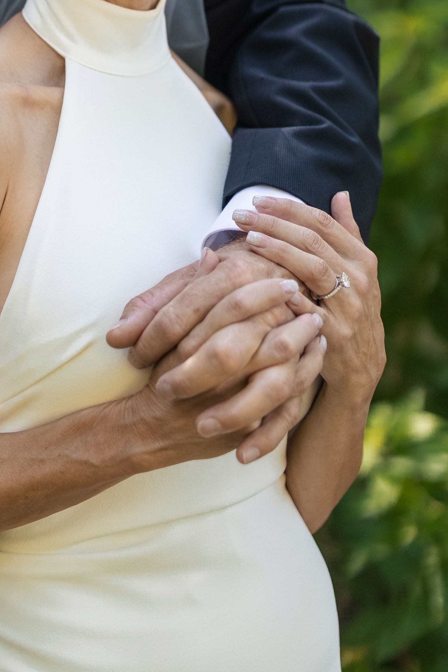 Close-up of hands embracing during an intimate wedding moment.