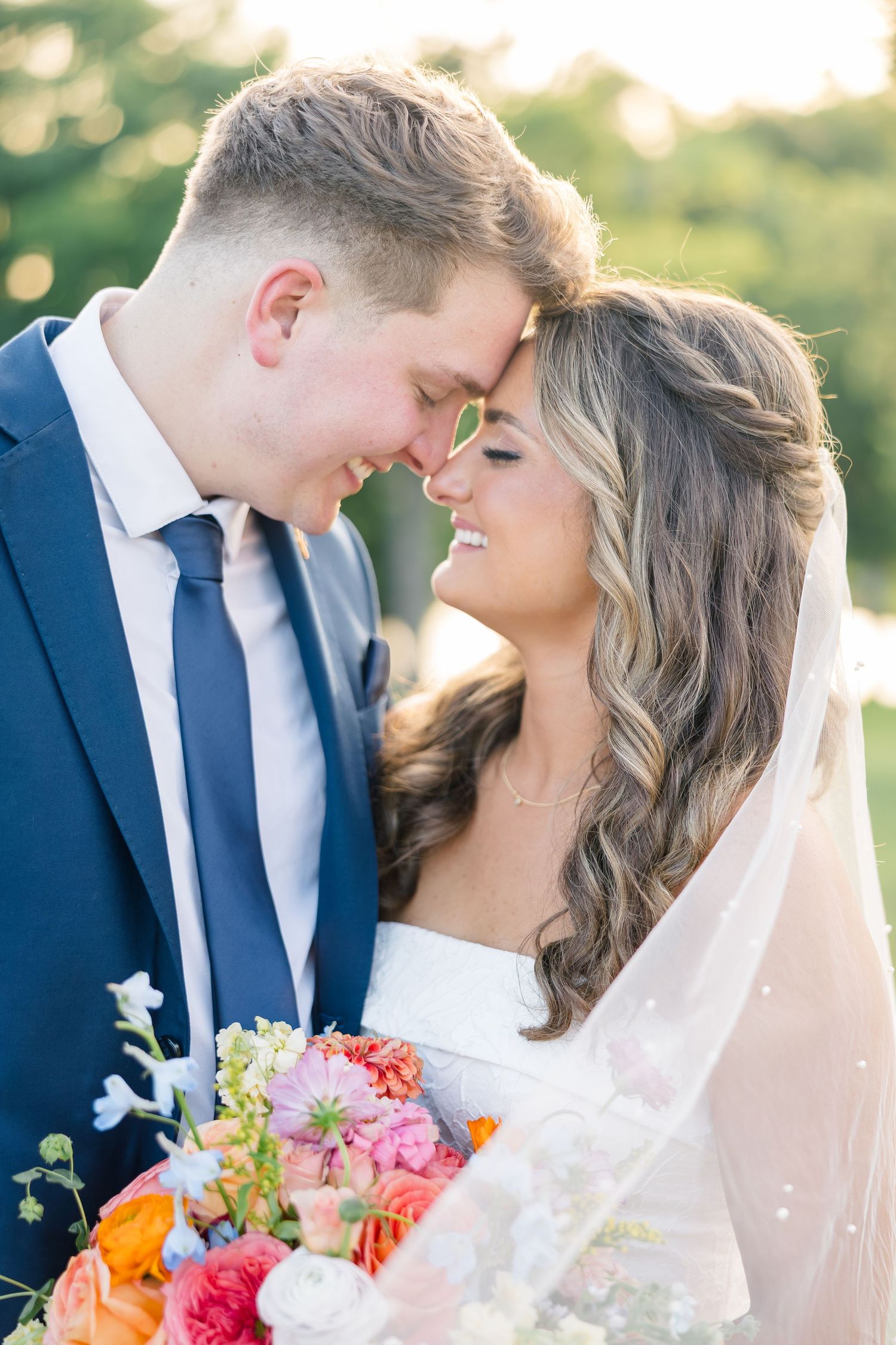 A romantic wedding couple shares intimate moments in a garden setting with colorful bouquet of spring flowers. The Delanie Venue Forney TX