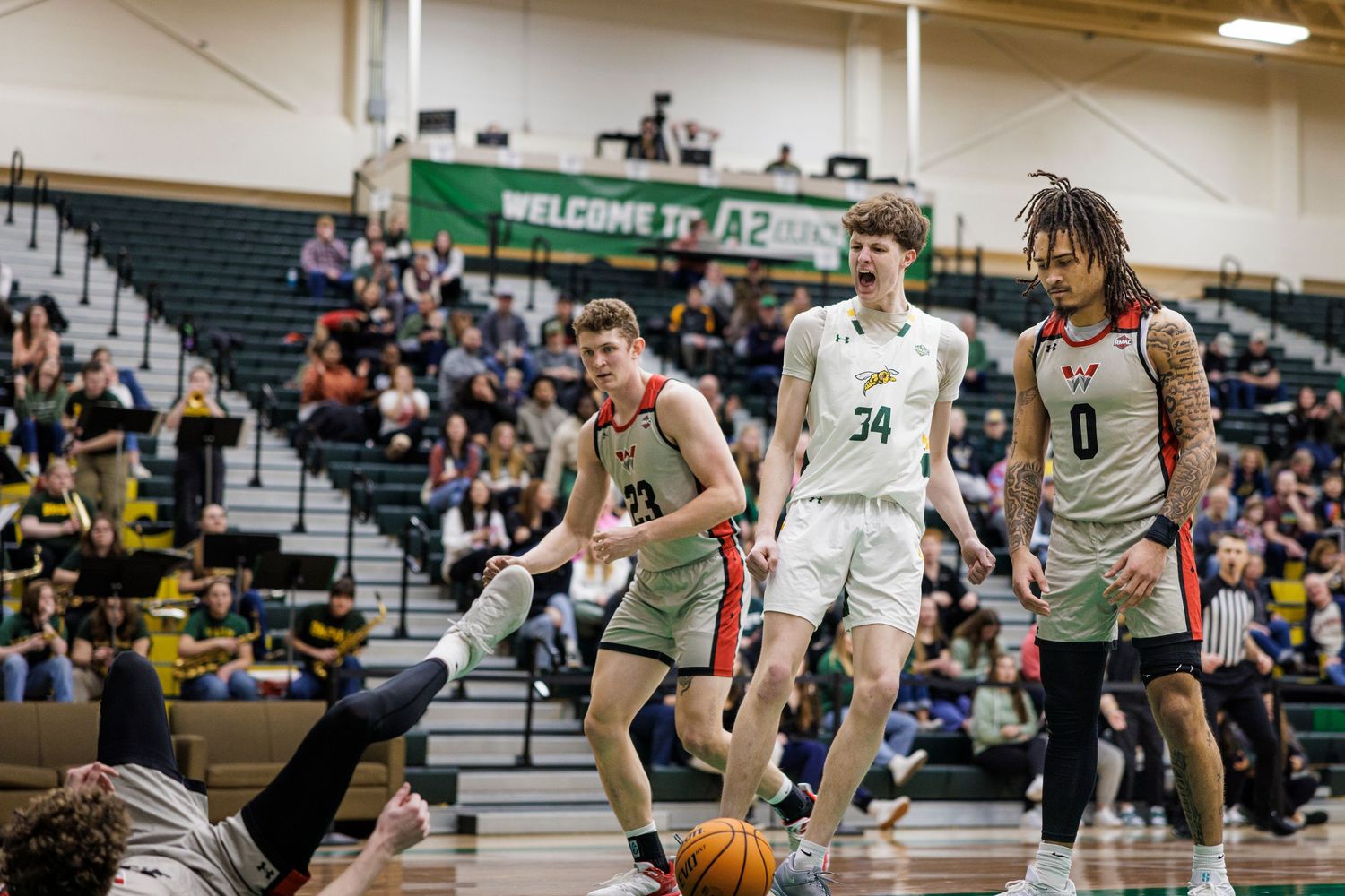 Players from two teams battle for position during an indoor basketball game.