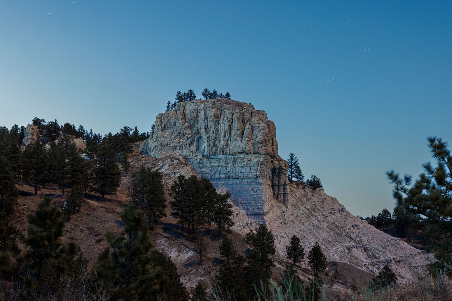 Panoramic view of rocky mountain formations against clear blue sky.