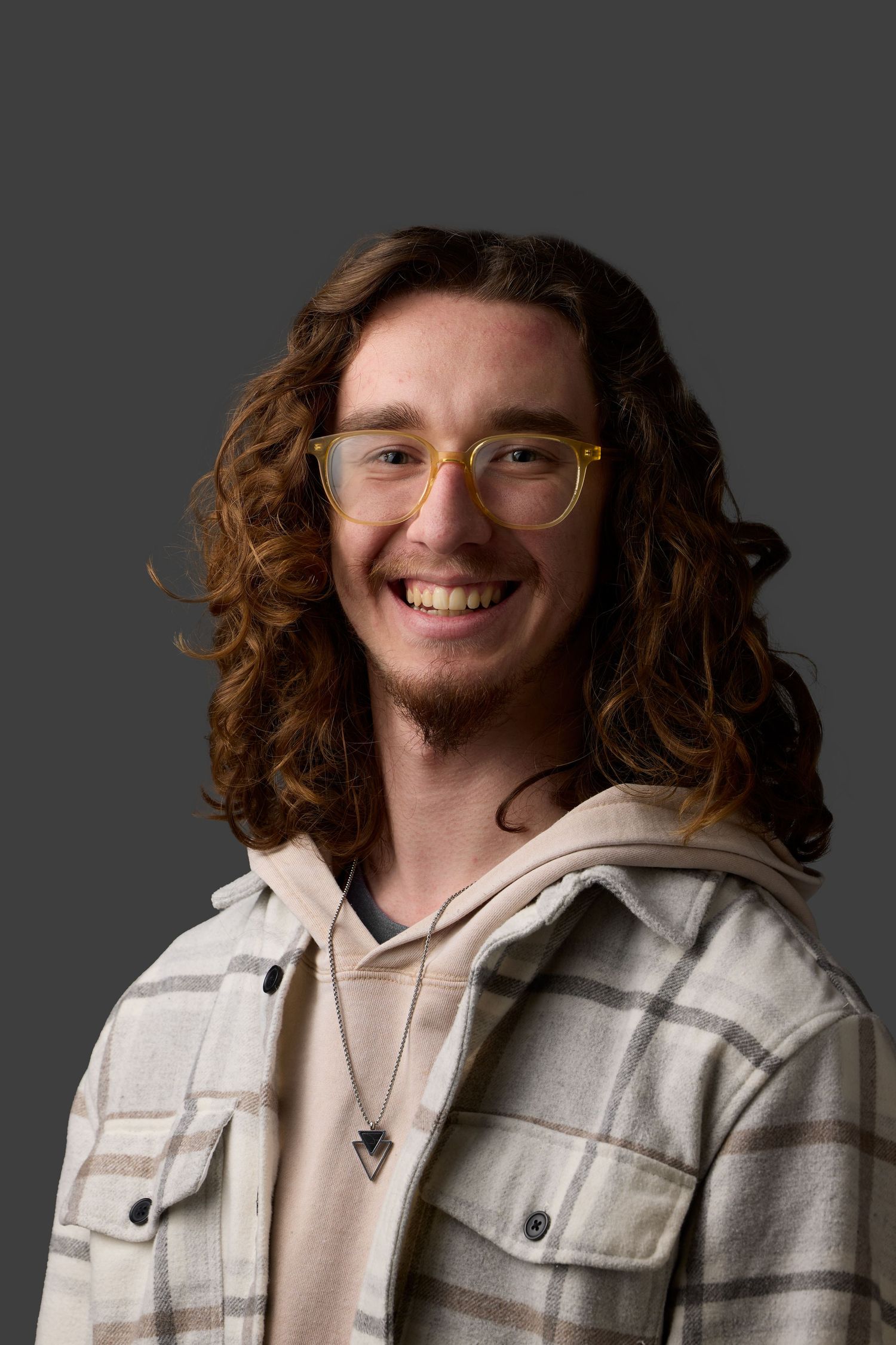 Portrait series showing a person in a plaid jacket with curly hair against a gray backdrop.