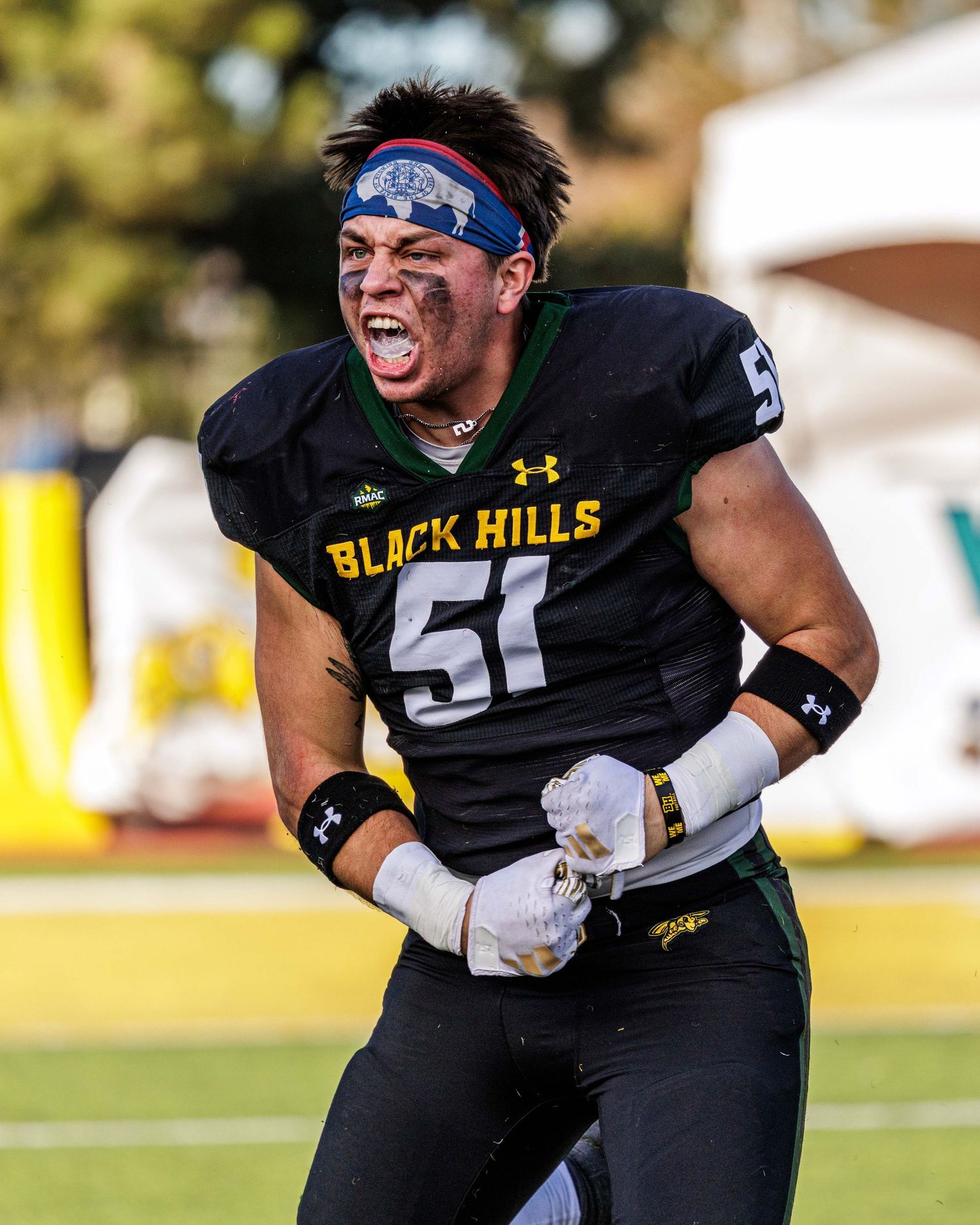 Football players in black and white uniforms celebrating during a game with intense emotion and energy.