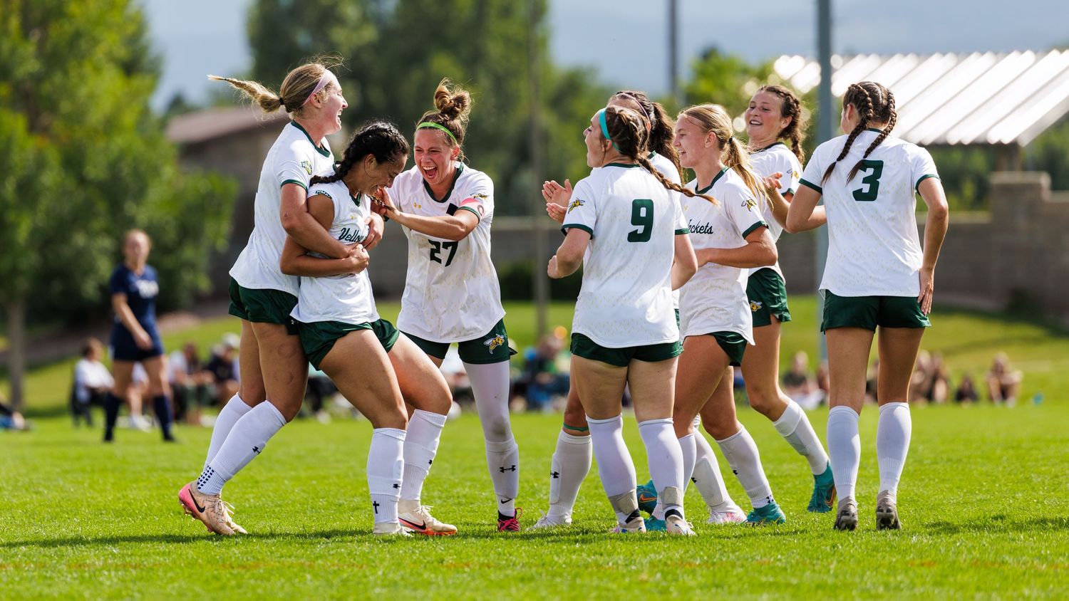 Soccer players warming up on a green field with white uniforms.
