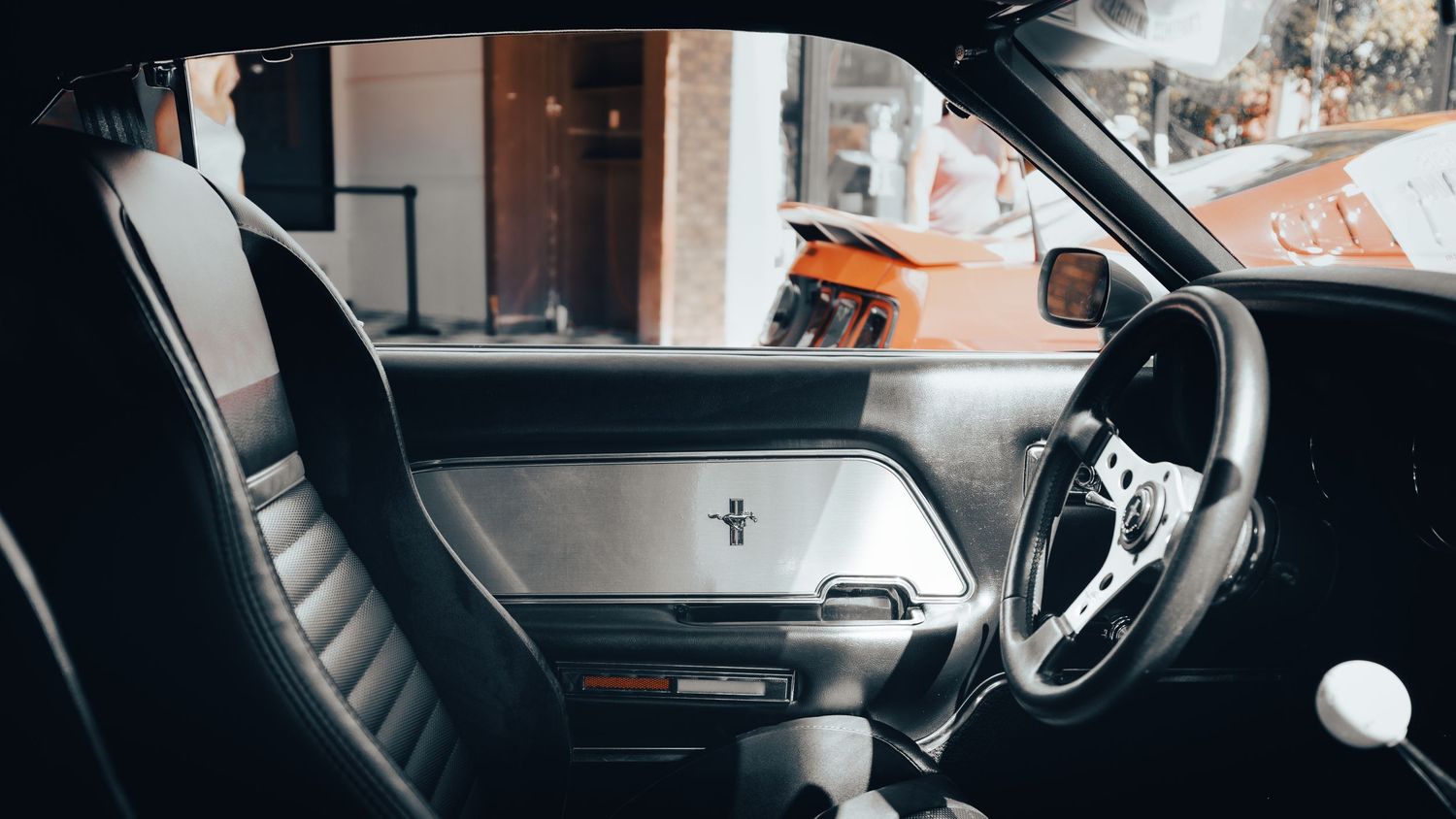 Interior view of a car dashboard and windshield with lens flare.