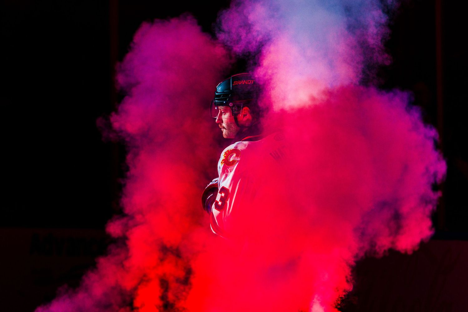 Vibrant pink and purple smoke clouds swirl dramatically against a dark background creating an ethereal atmosphere.