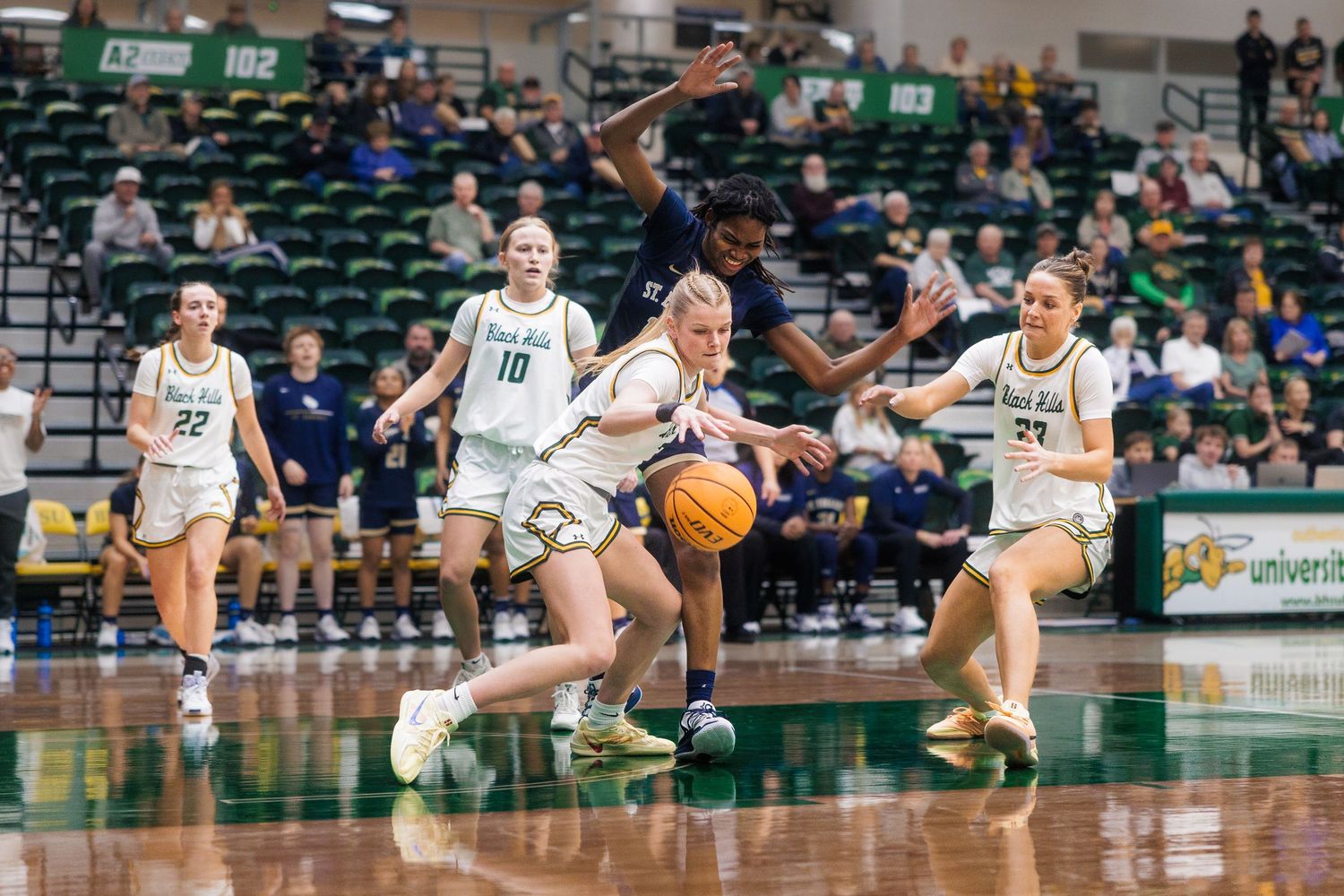 Basketball players diving for a loose ball during an intense game sequence.