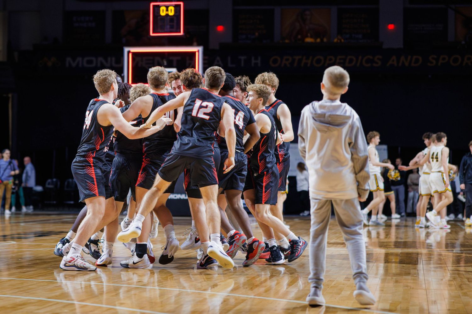 Basketball players battle for possession during an intense game on the court.
