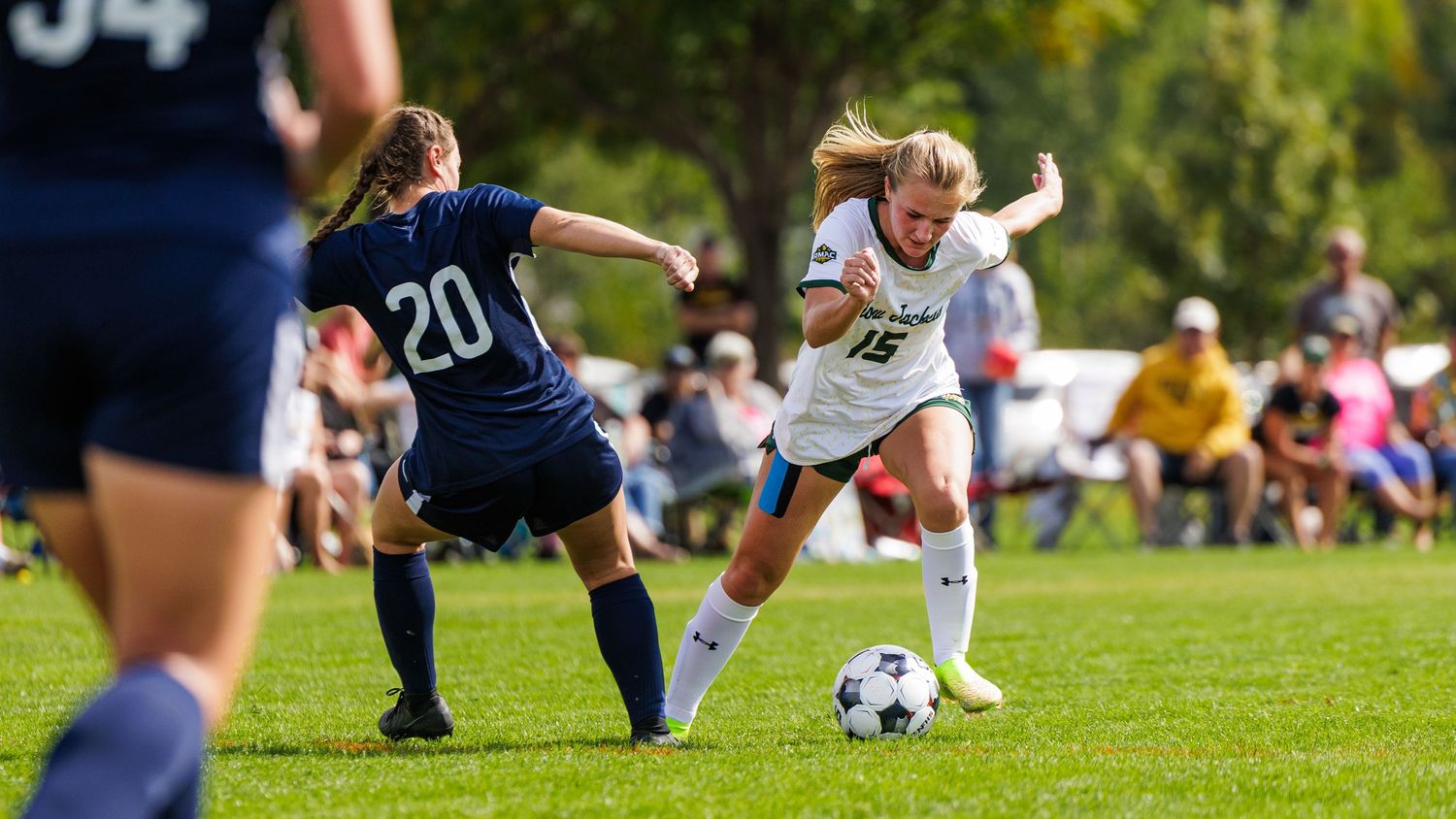 Athletes competing on a grass field during a sports match.