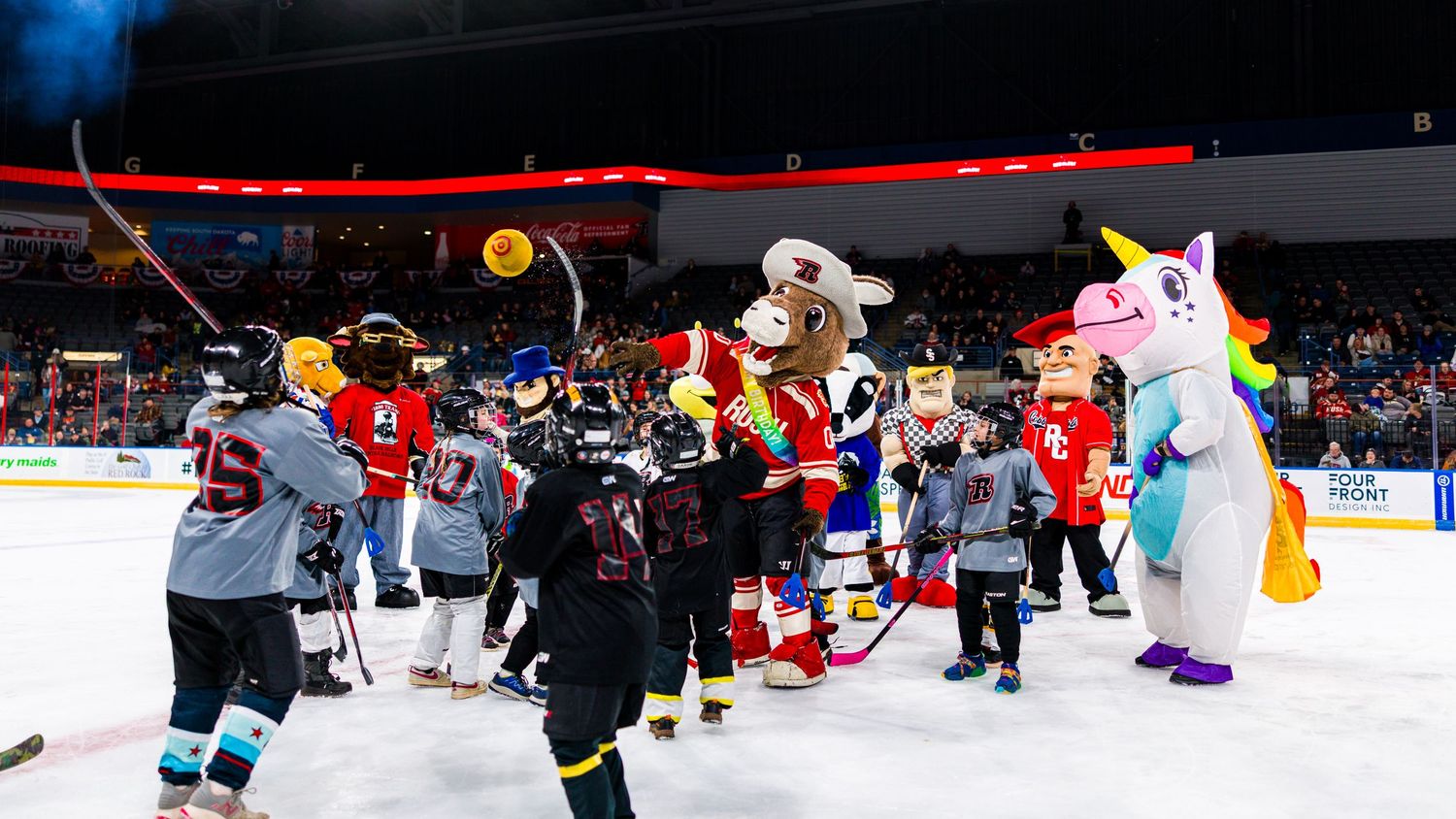 Hockey players collide and scramble for the puck during an intense game on the ice rink.