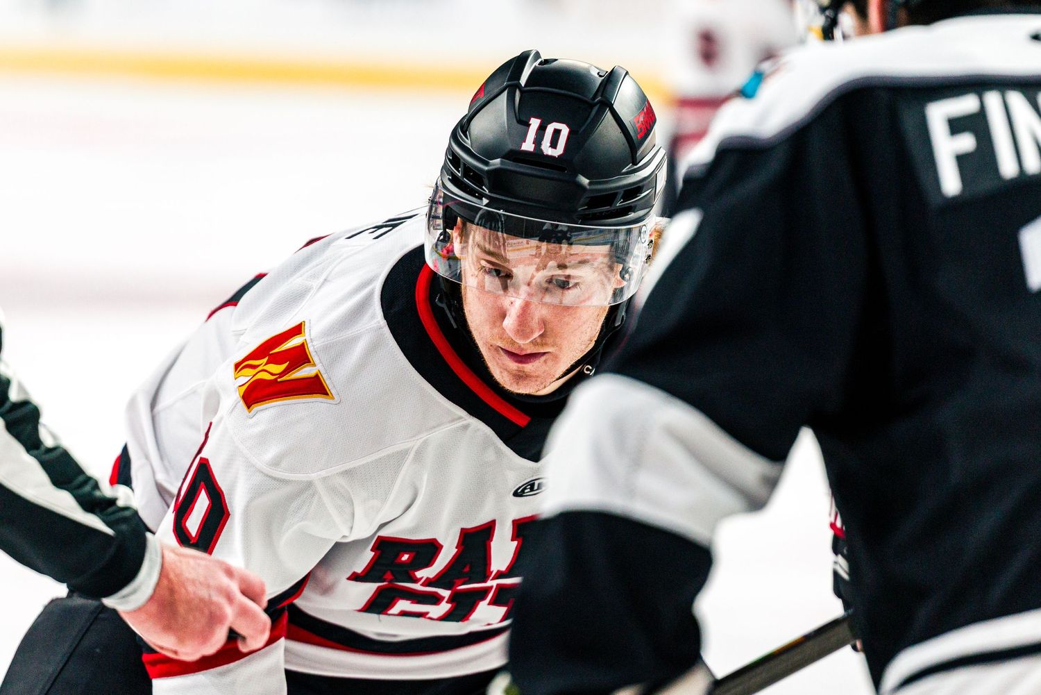 Hockey players battle for the puck during an intense NHL game with players in white and dark jerseys.