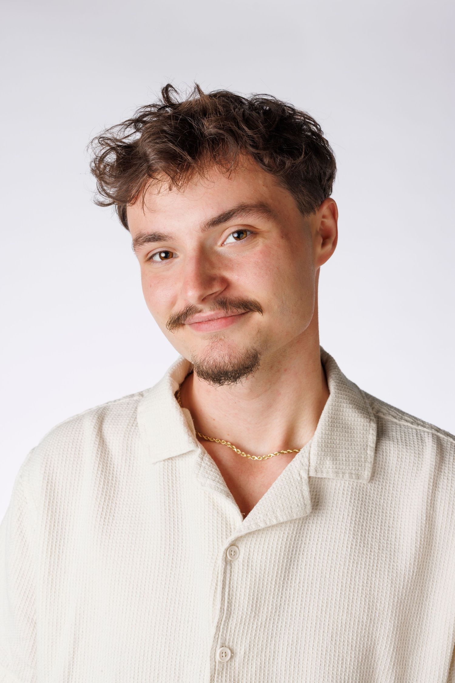 Portrait shot against white background showcasing playful expression.