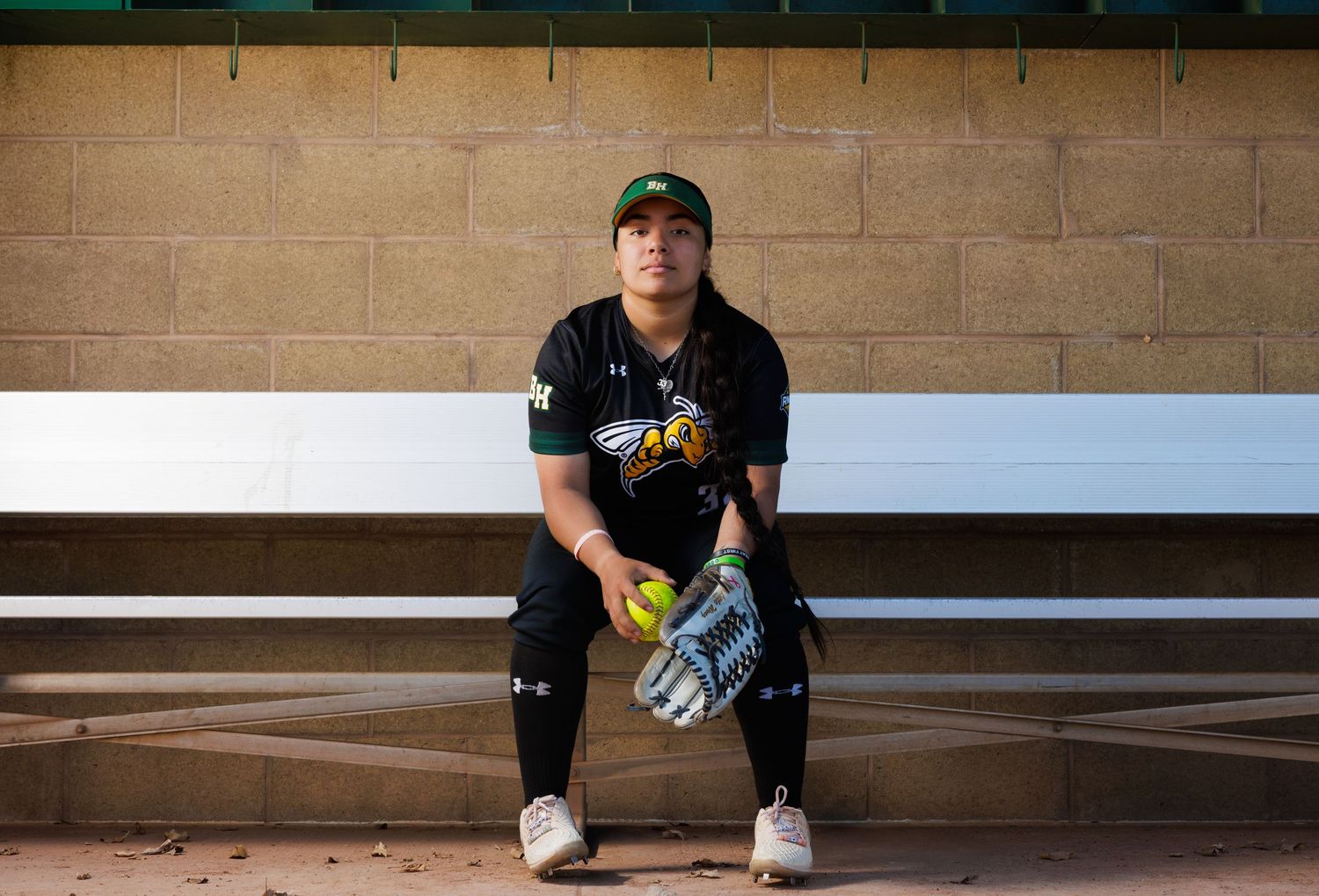 Person sitting alone on concrete steps in casual attire and baseball cap.
