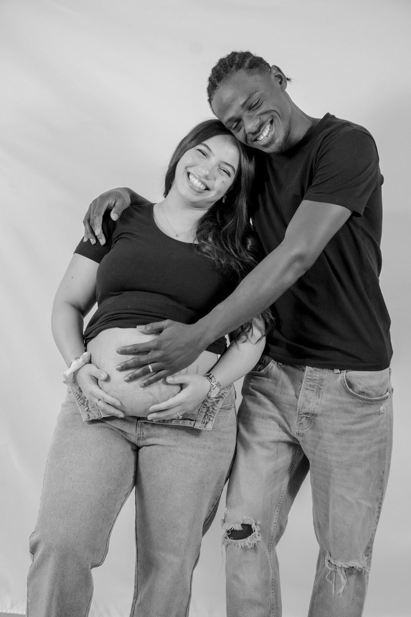 Black and white sequence showing a couple in casual clothing embracing and sharing playful moments together.