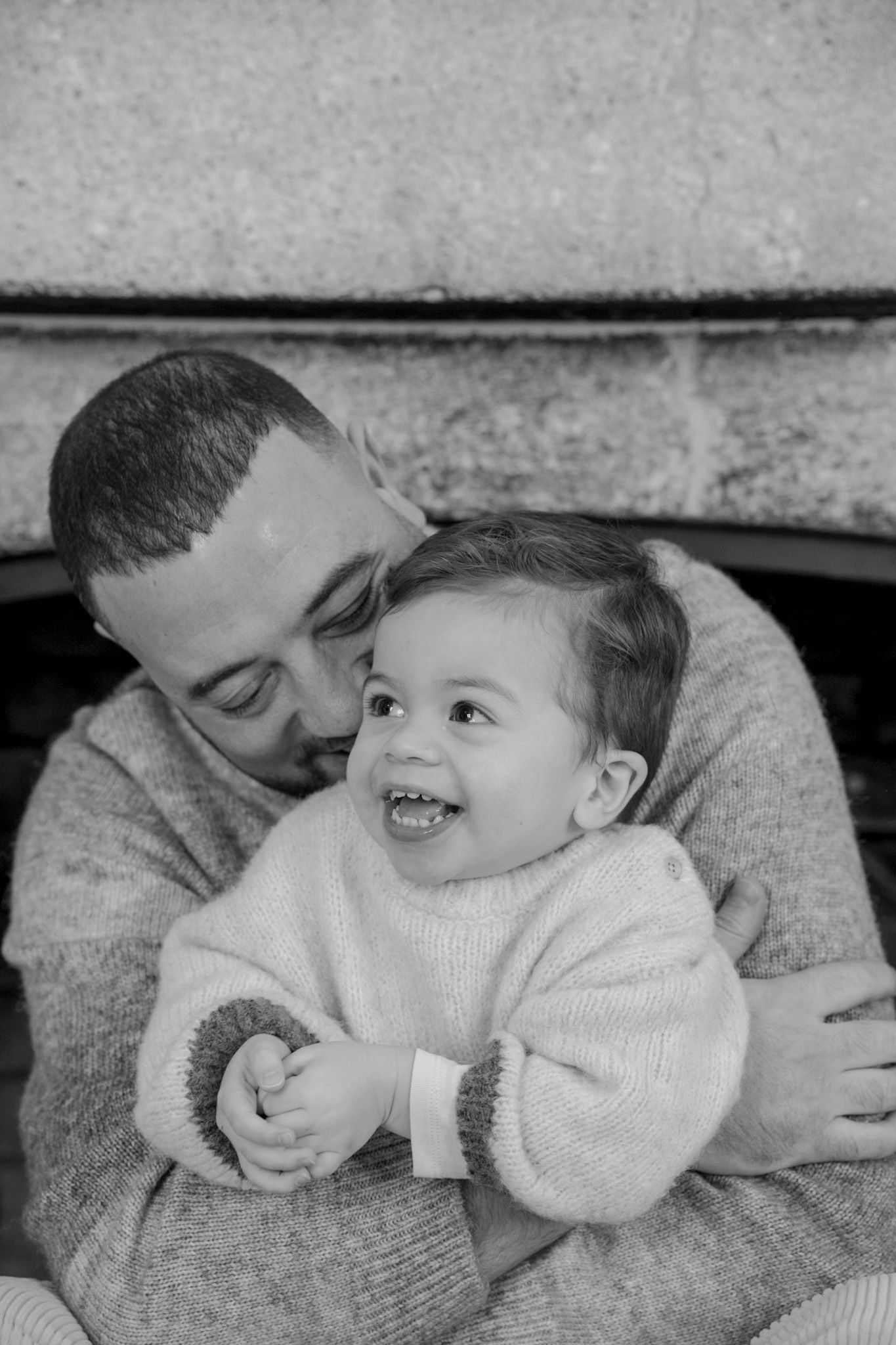 A tender black and white sequence shows an adult and child sharing loving moments together on a couch.