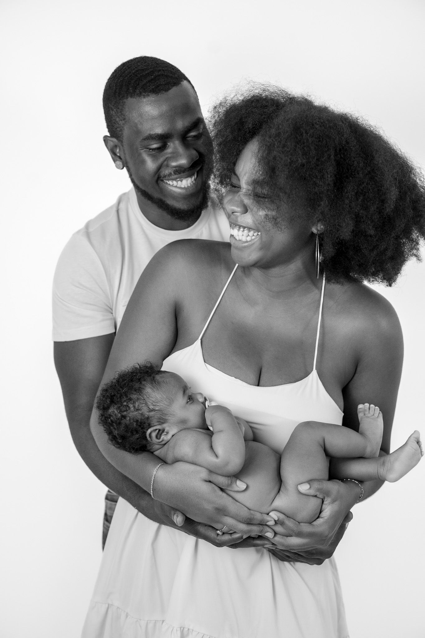 A happy couple embraces and laughs together in a series of black and white photographs showing tender moments.