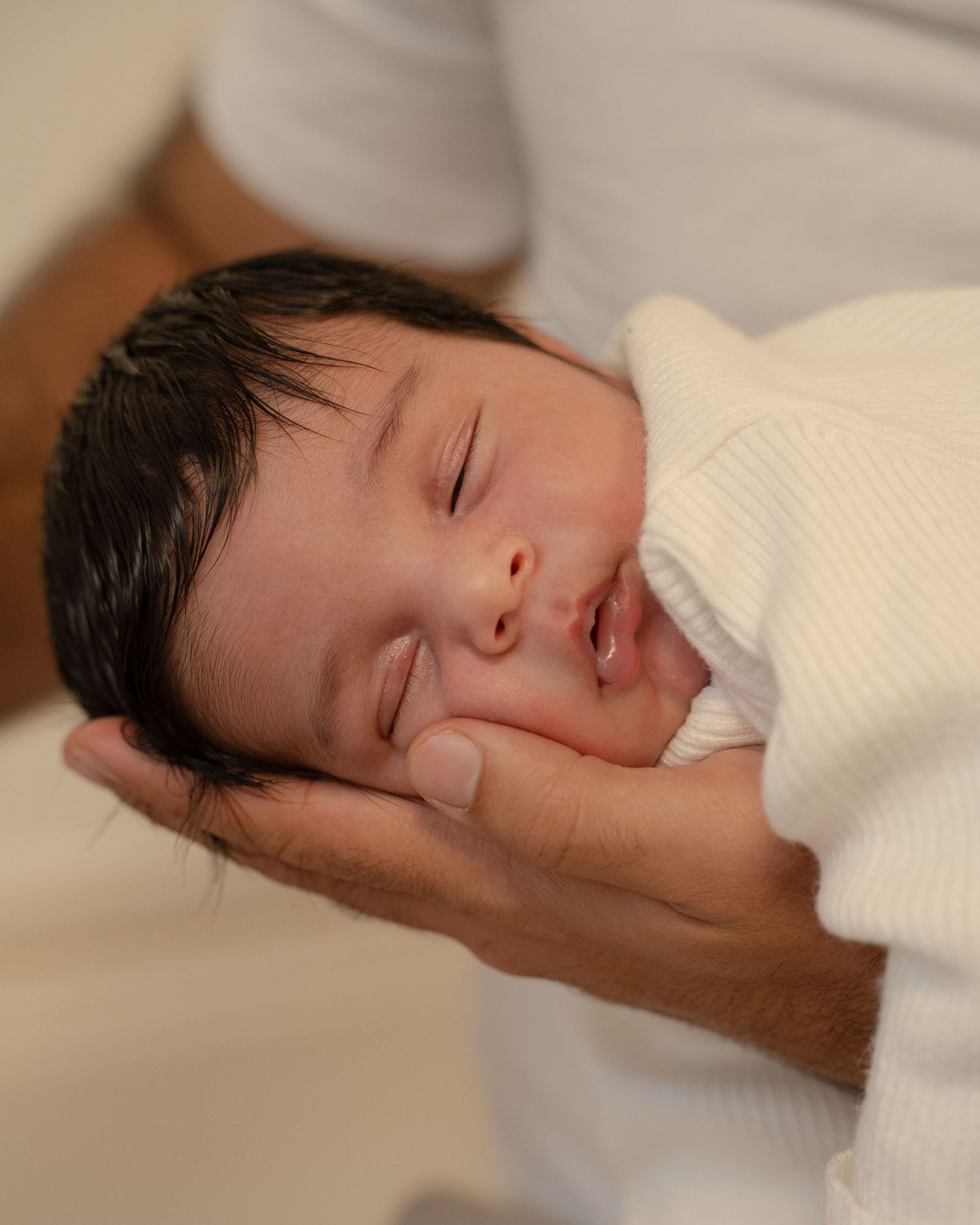 A sleeping baby rests peacefully on white bedding in a series of close-up shots.