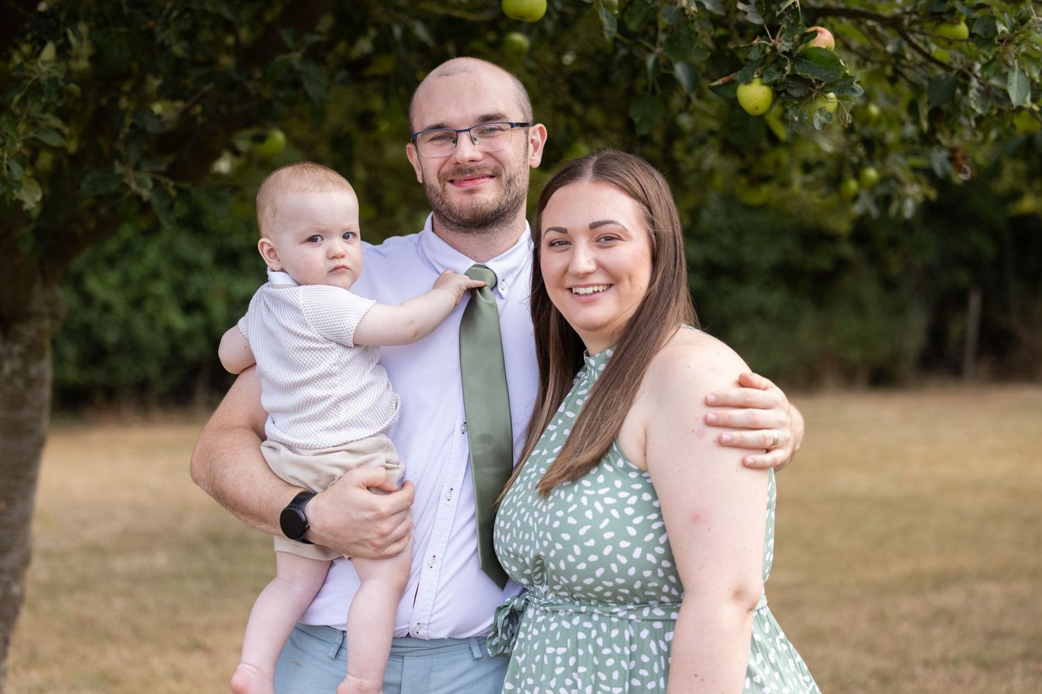A young family posing at a wedding