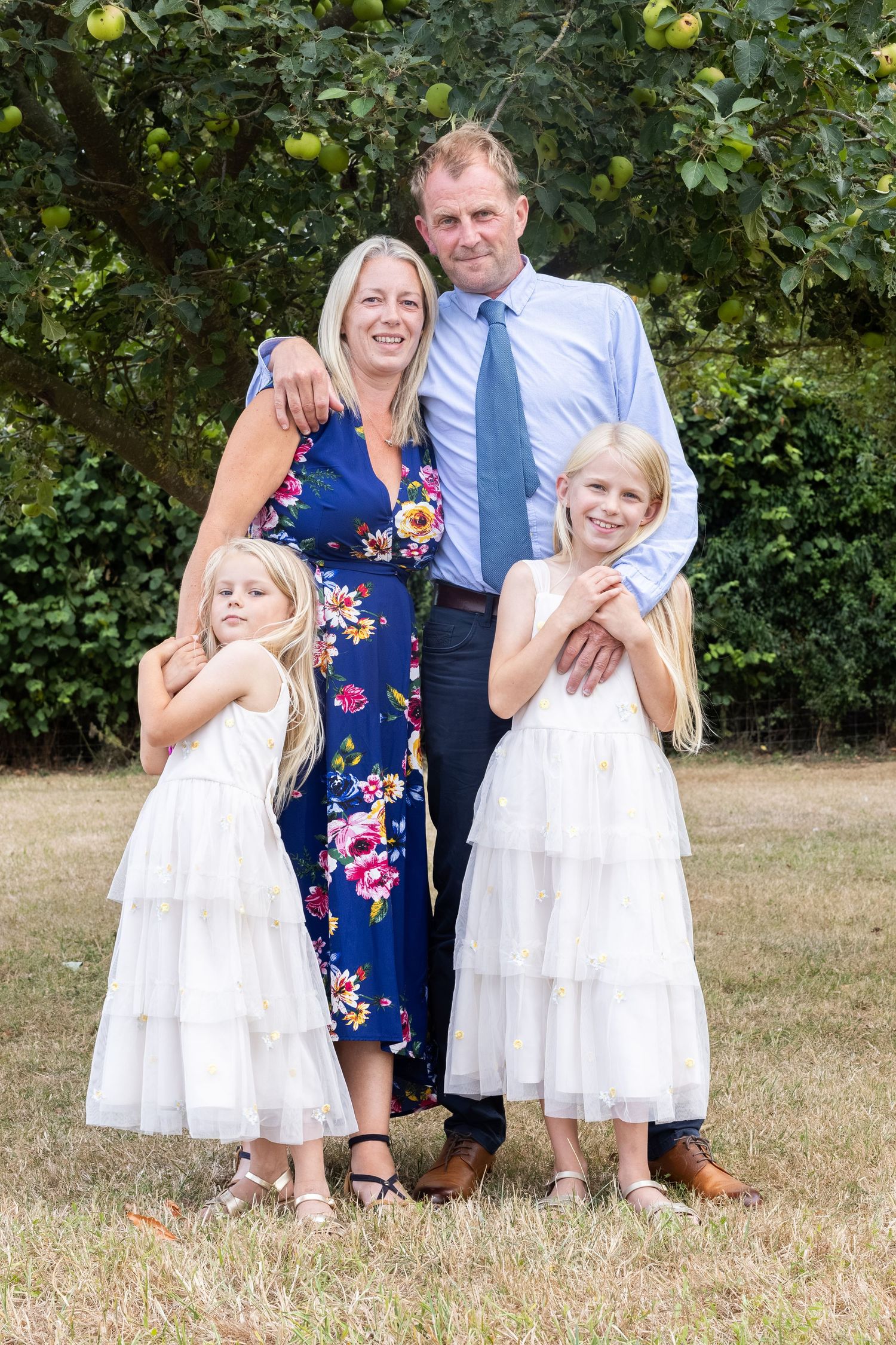 A young famly posing at a wedding