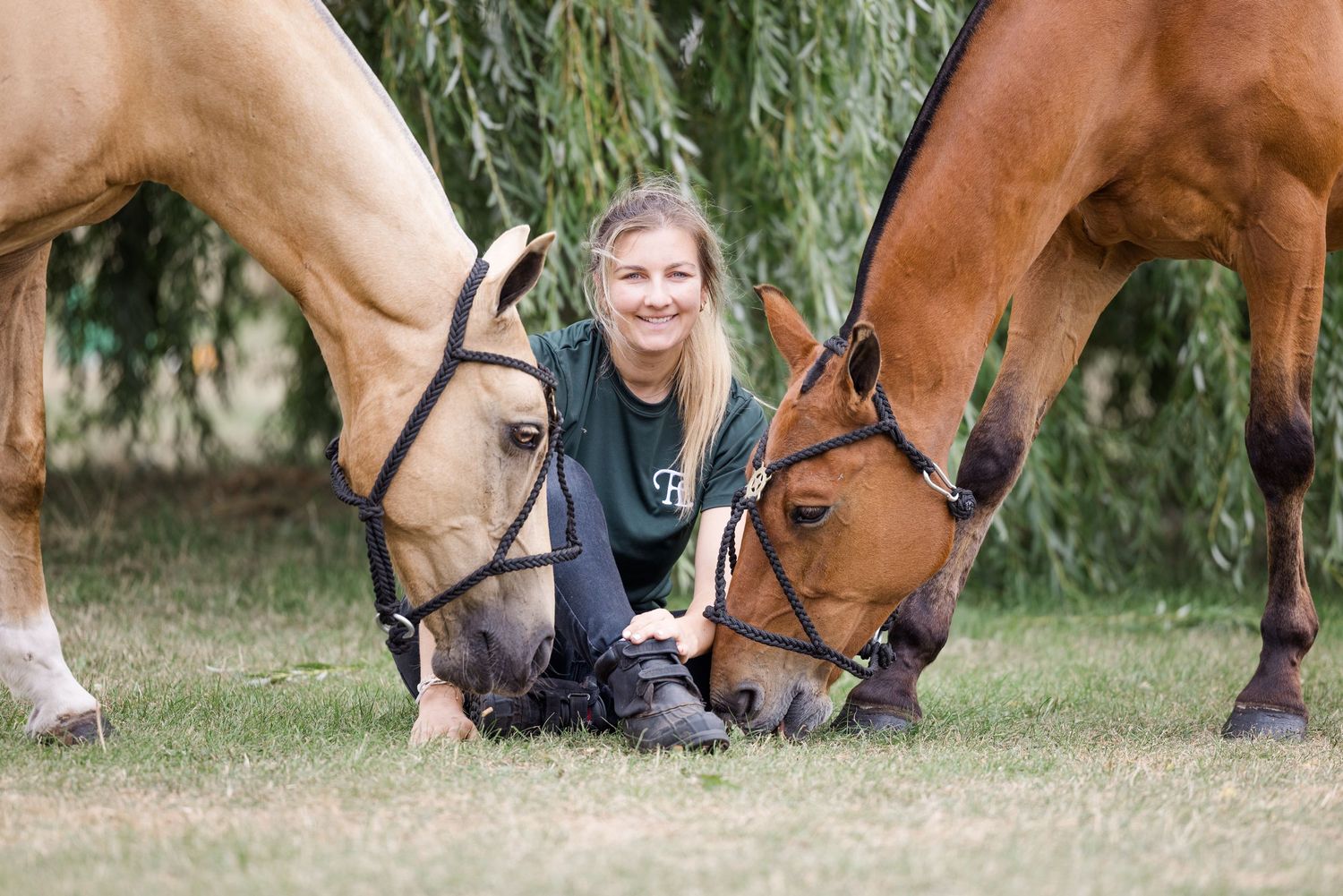 A smiling lady with her polo ponies