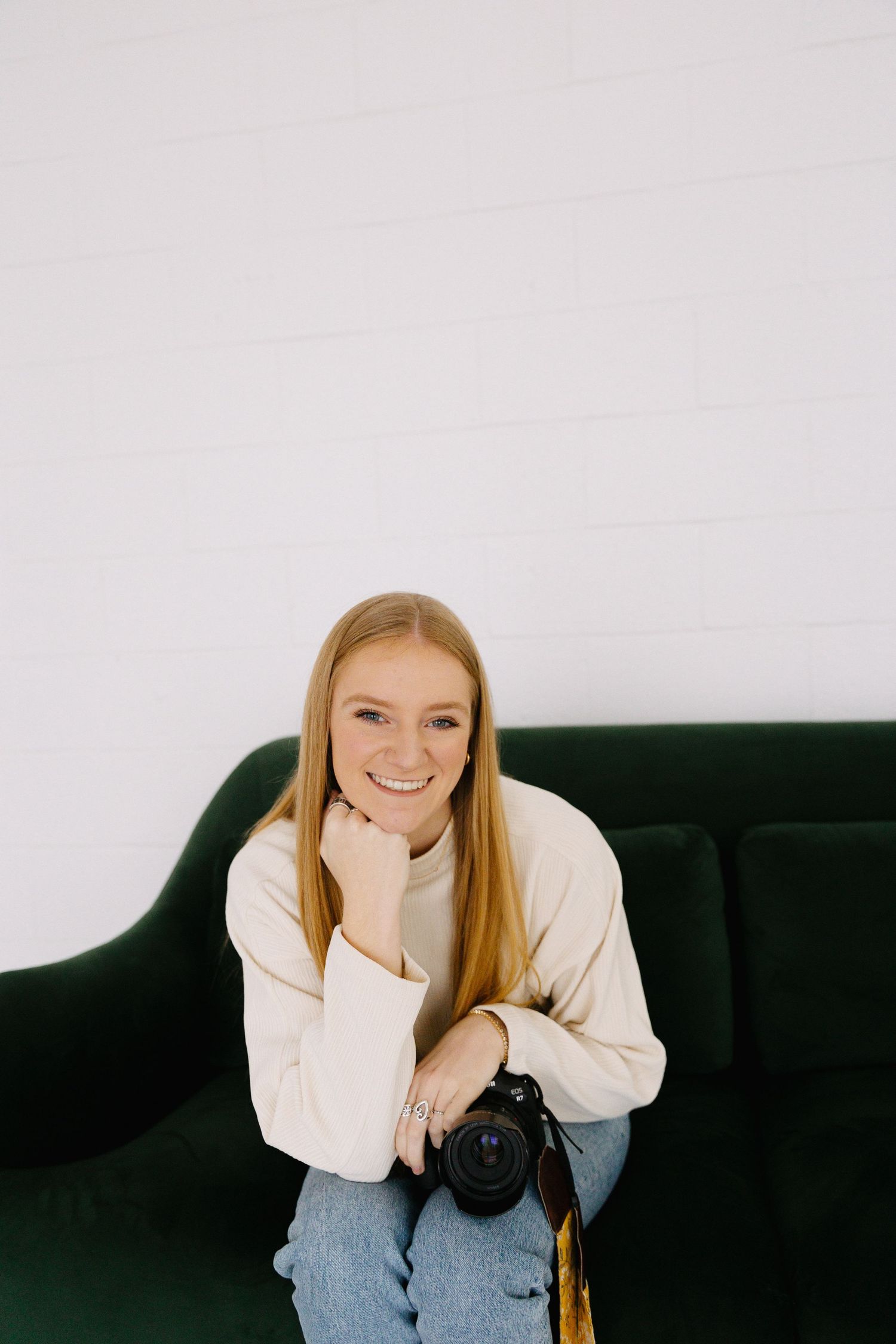 Artistic portrait series on a green couch showing casual poses against white studio backdrop.
