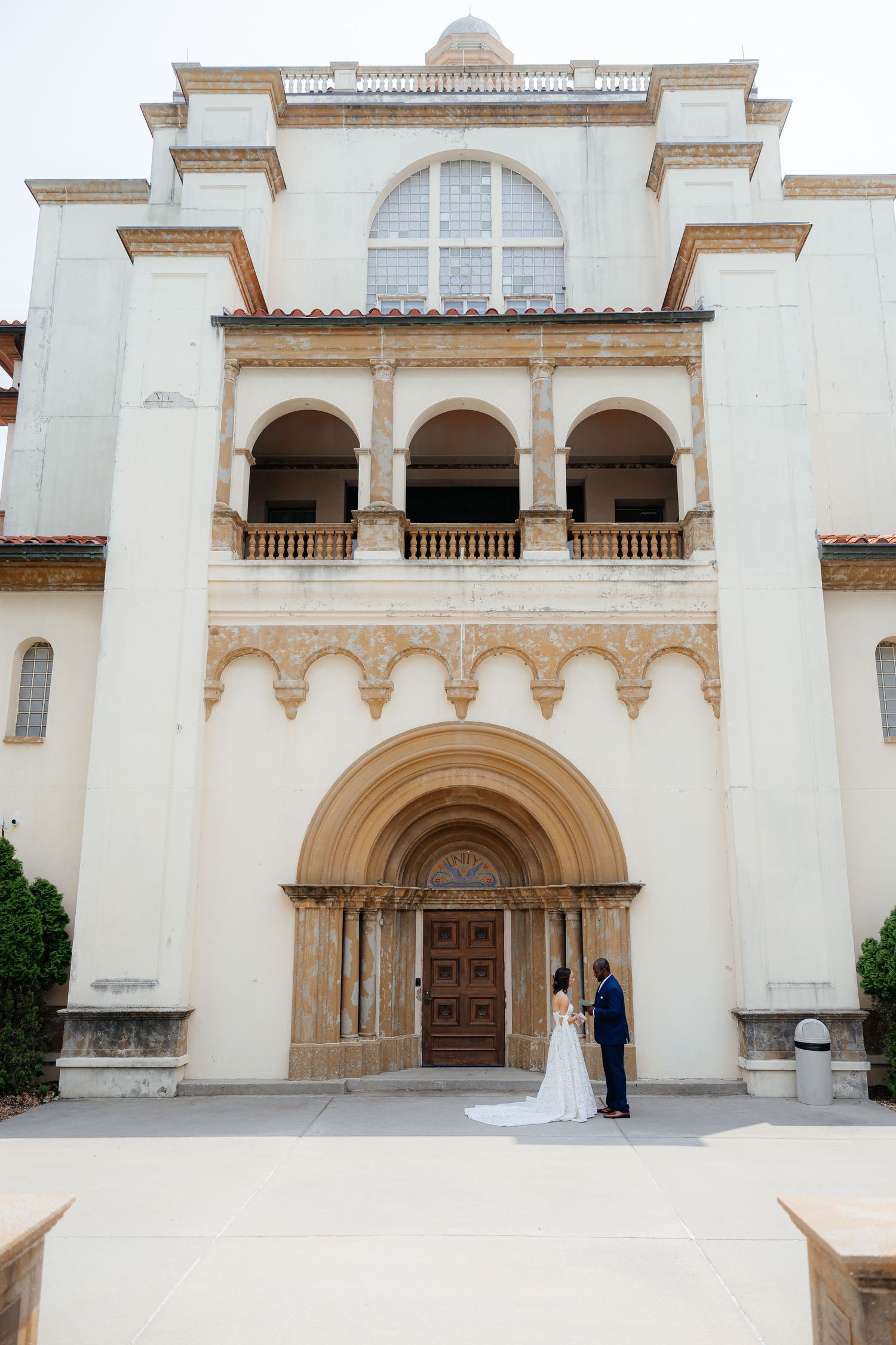 Classic white stone building facade with arched doorways and ornate architectural details.