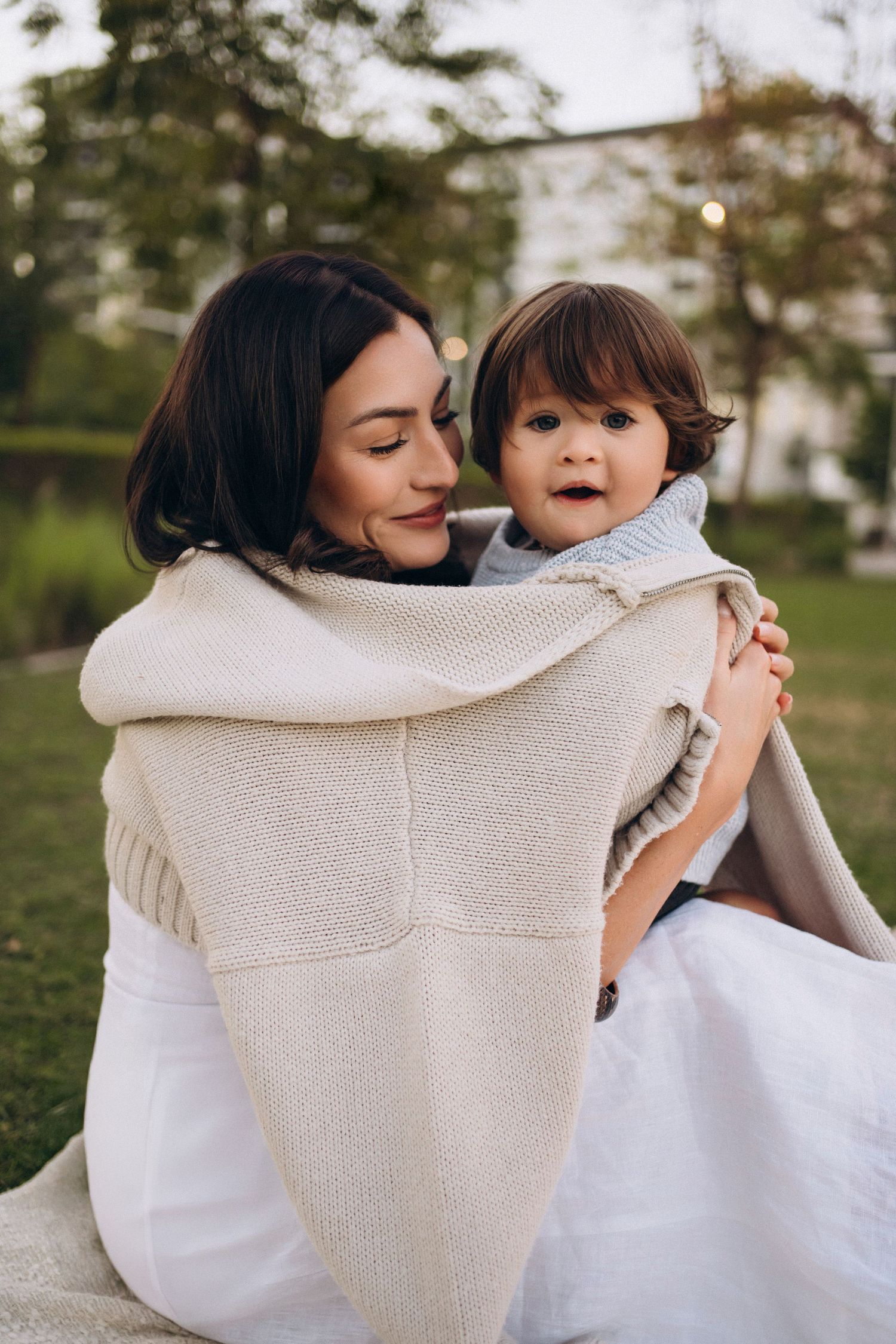 An intimate portrait of parent and child sharing a warm embrace outdoors.