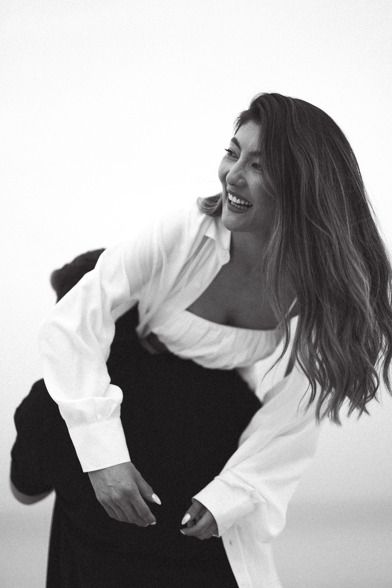 Artistic portrait of someone in black and white outfit creating dynamic motion.