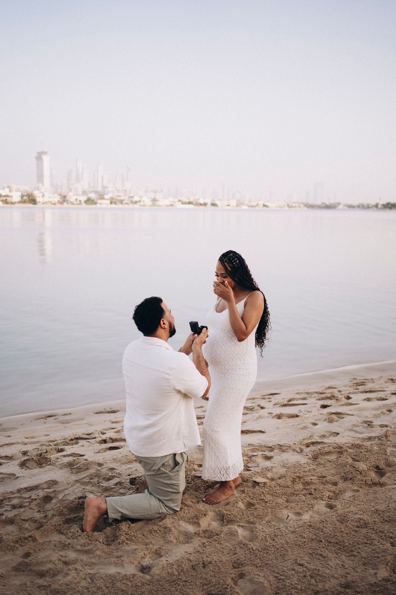 Marriage proposal scene with cityscape backdrop during sunset.