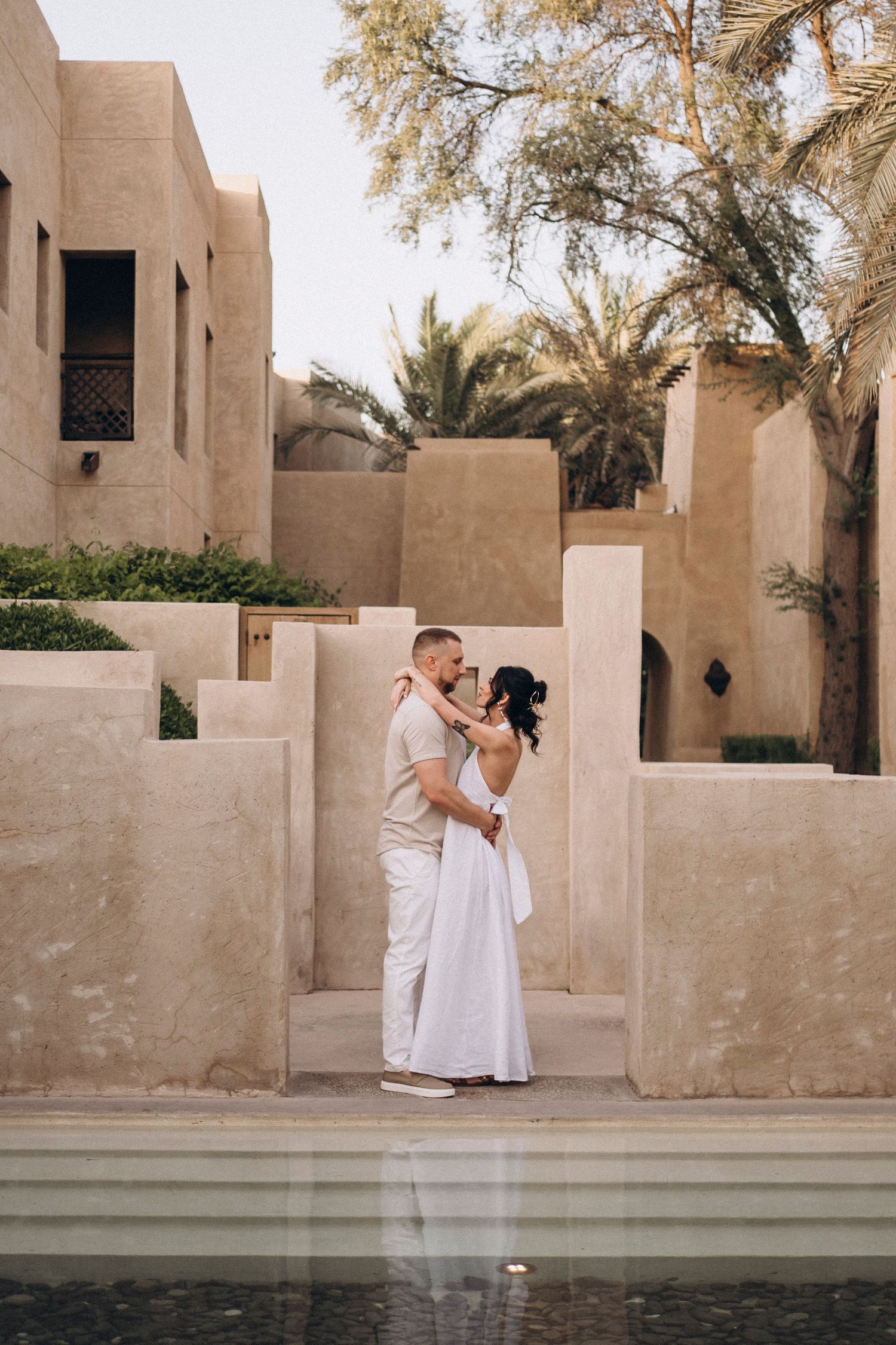 Desert architecture featuring sand-colored walls and geometric designs around a serene pool.