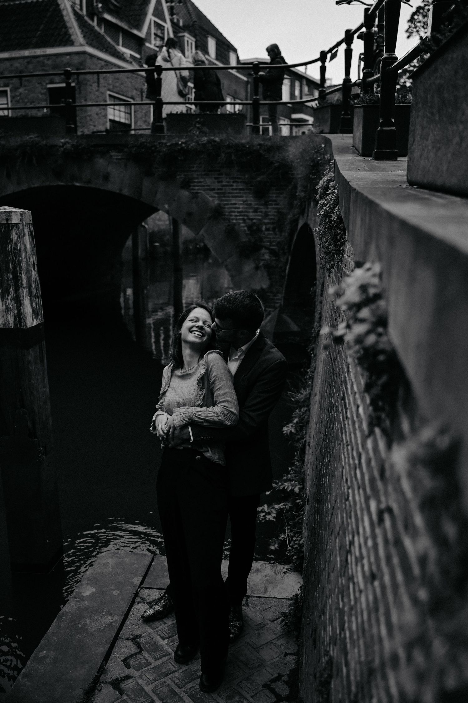 Four black and white photographs showing a person joyfully playing near a wall in an urban alleyway setting.