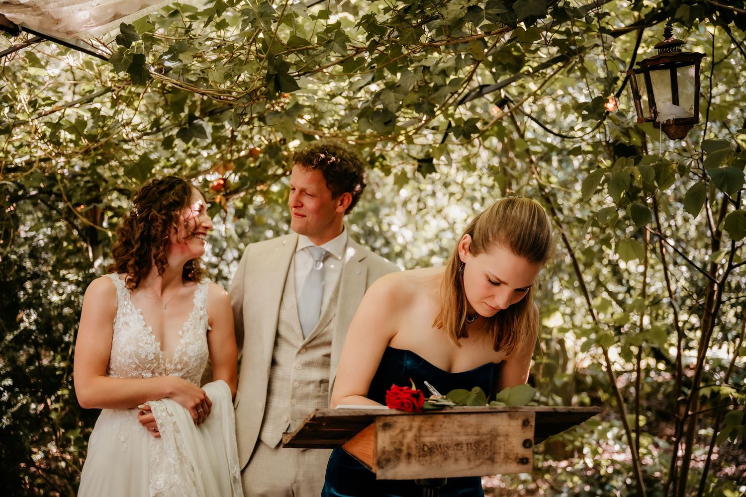 Wedding party moment in lush garden setting with natural light filtering through leaves.