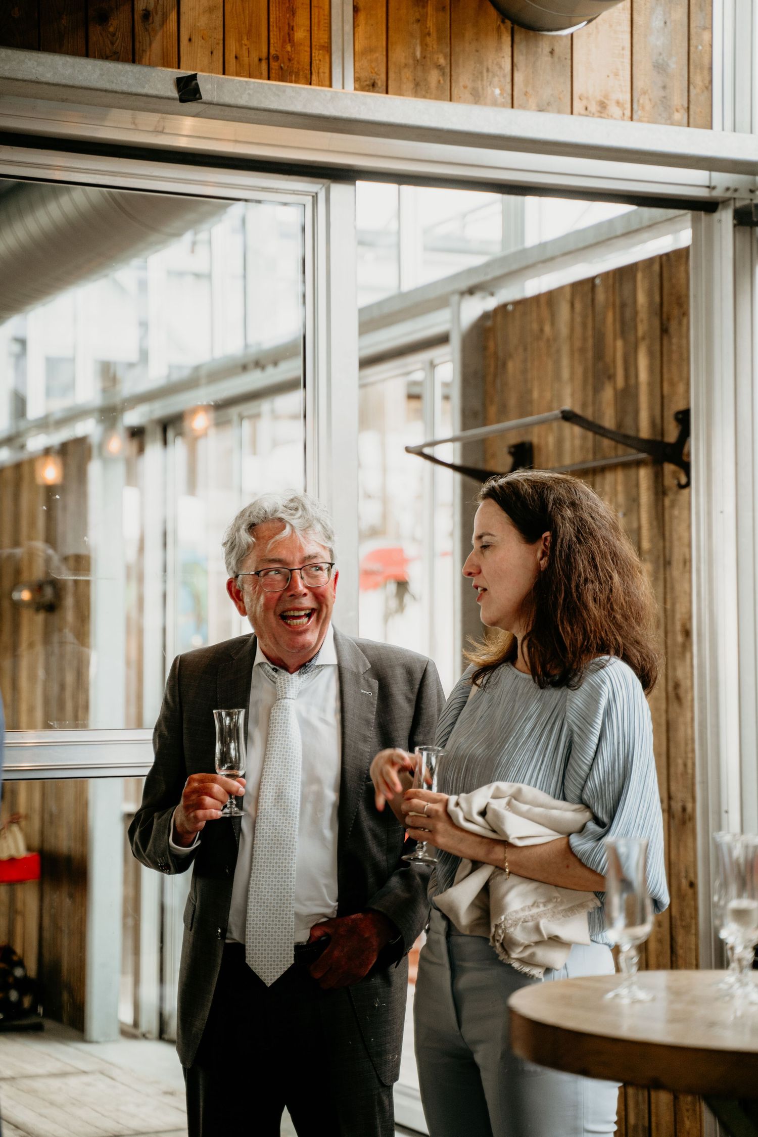 Joyful conversation in a rustic wooden interior with natural light streaming through windows.