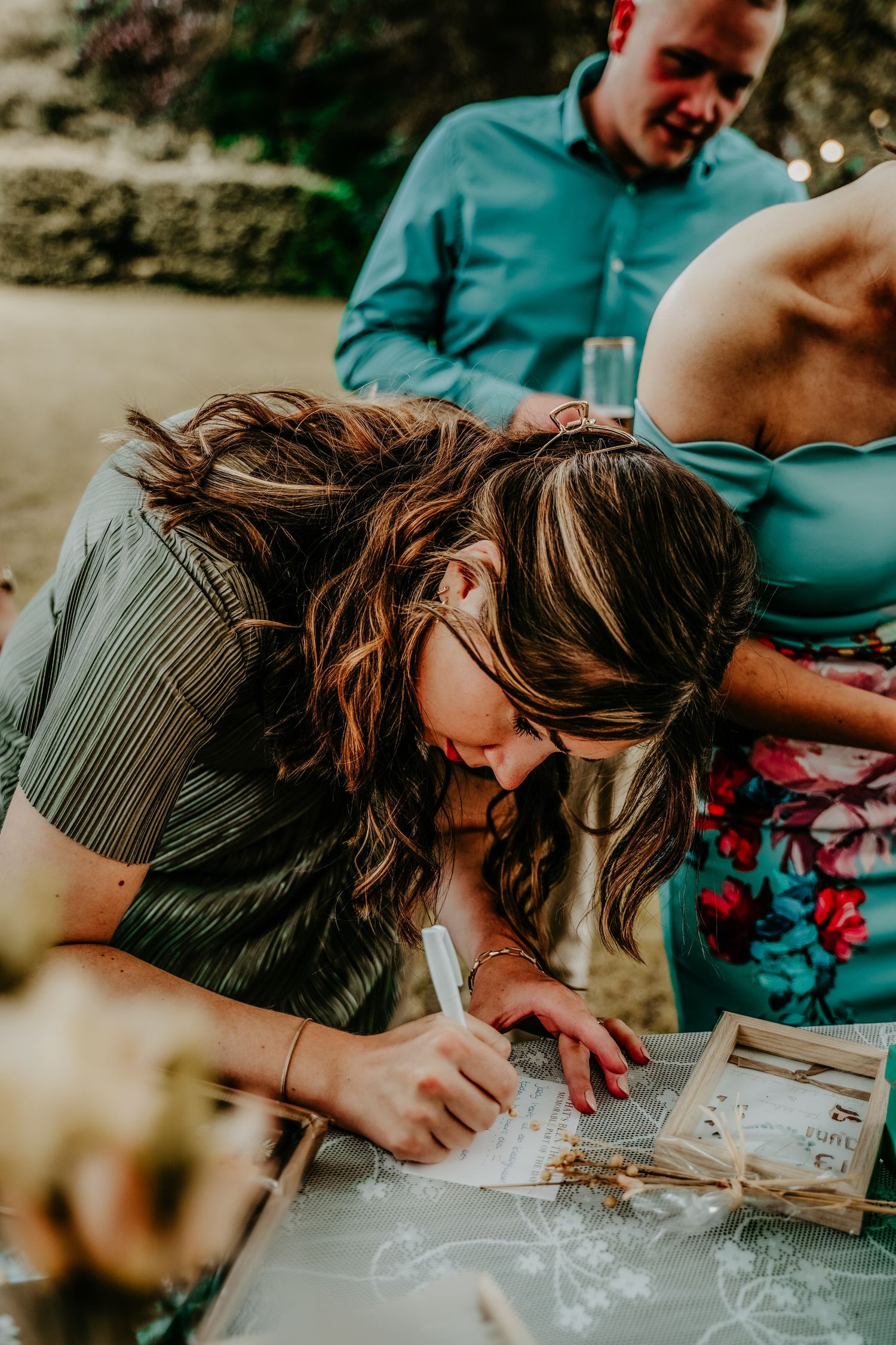 Person looking through a photo album outdoors in warm sunlight.