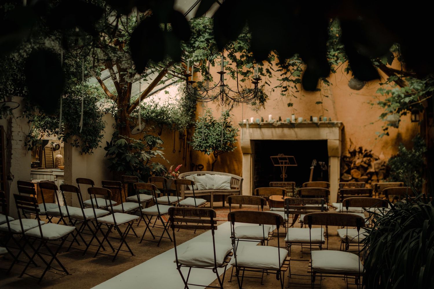 Empty wooden folding chairs arranged in rows for an outdoor wedding ceremony.