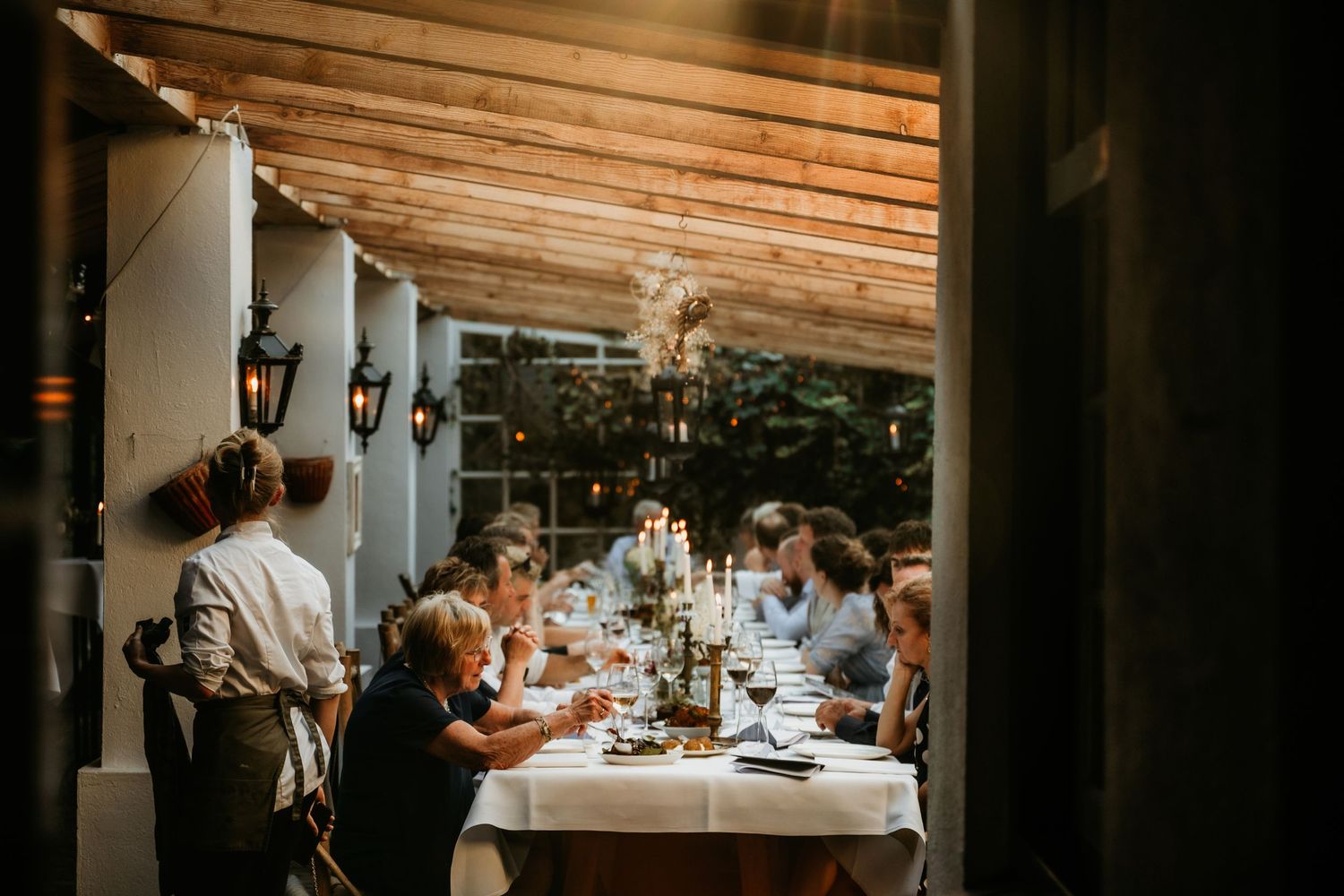 Wedding reception venue with wooden beams and intimate table settings.