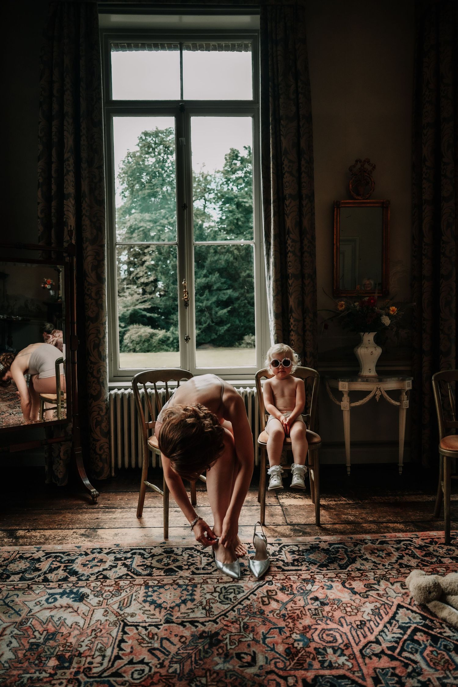 Elegant interior room with ornate patterned carpet and large windows letting in natural light.