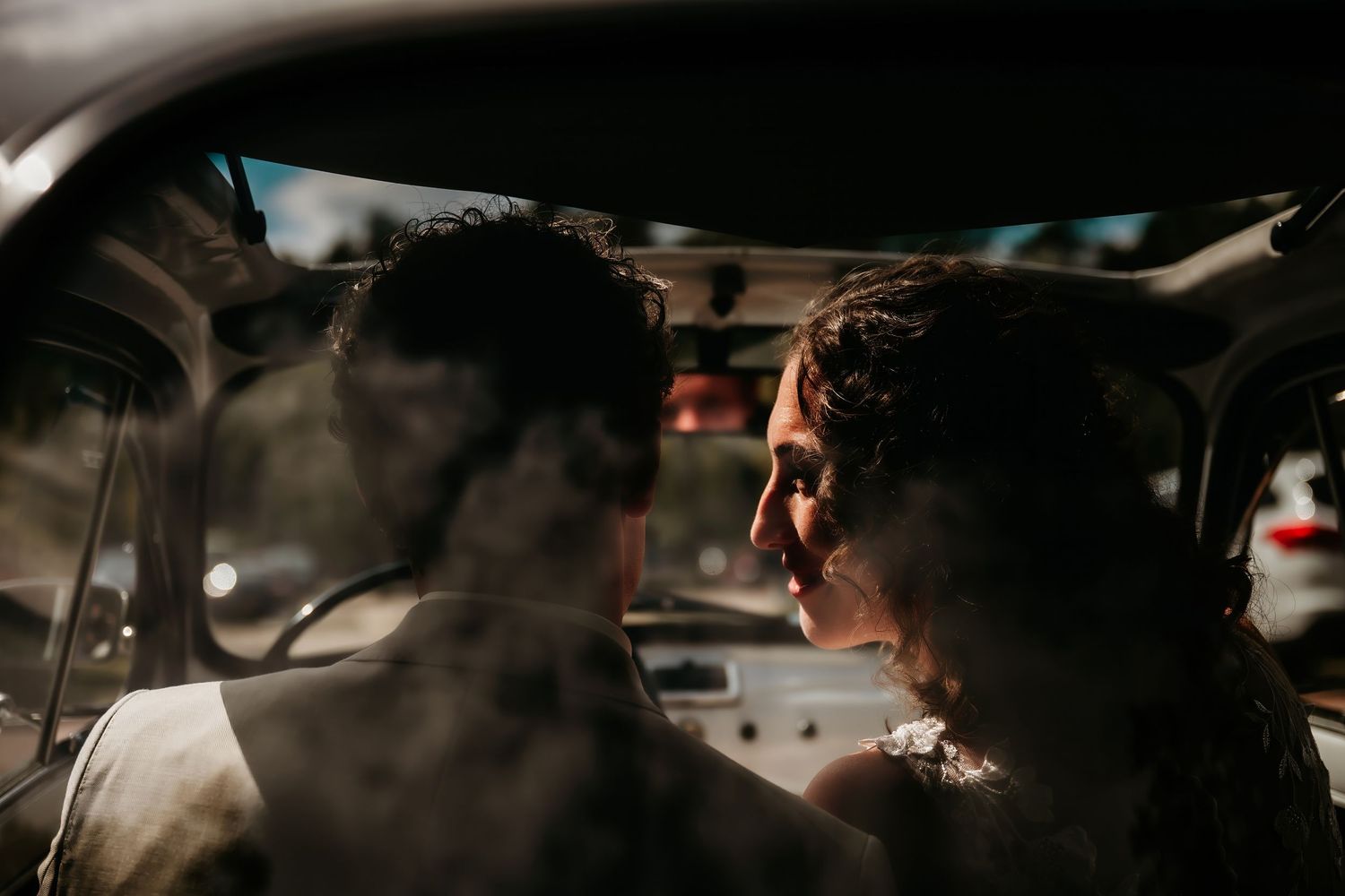 Interior view of a car with atmospheric lighting and smoke effects creating a moody ambiance.