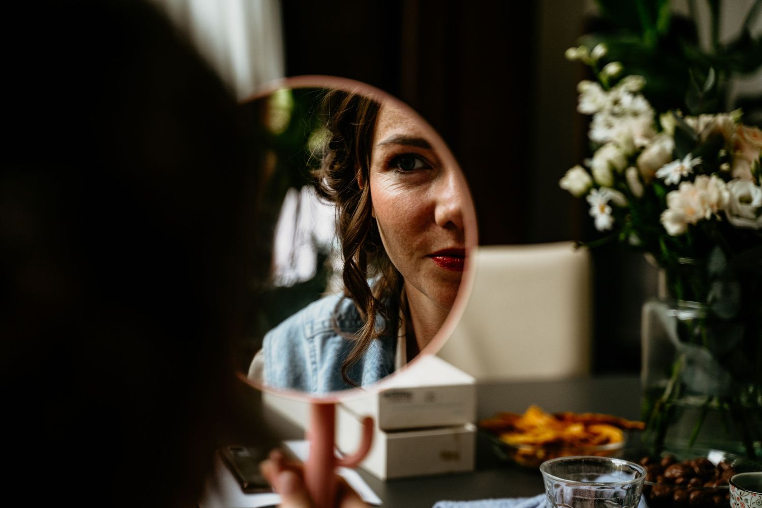 A candid wedding moment captured during an intimate celebration with floral arrangements and natural lighting.