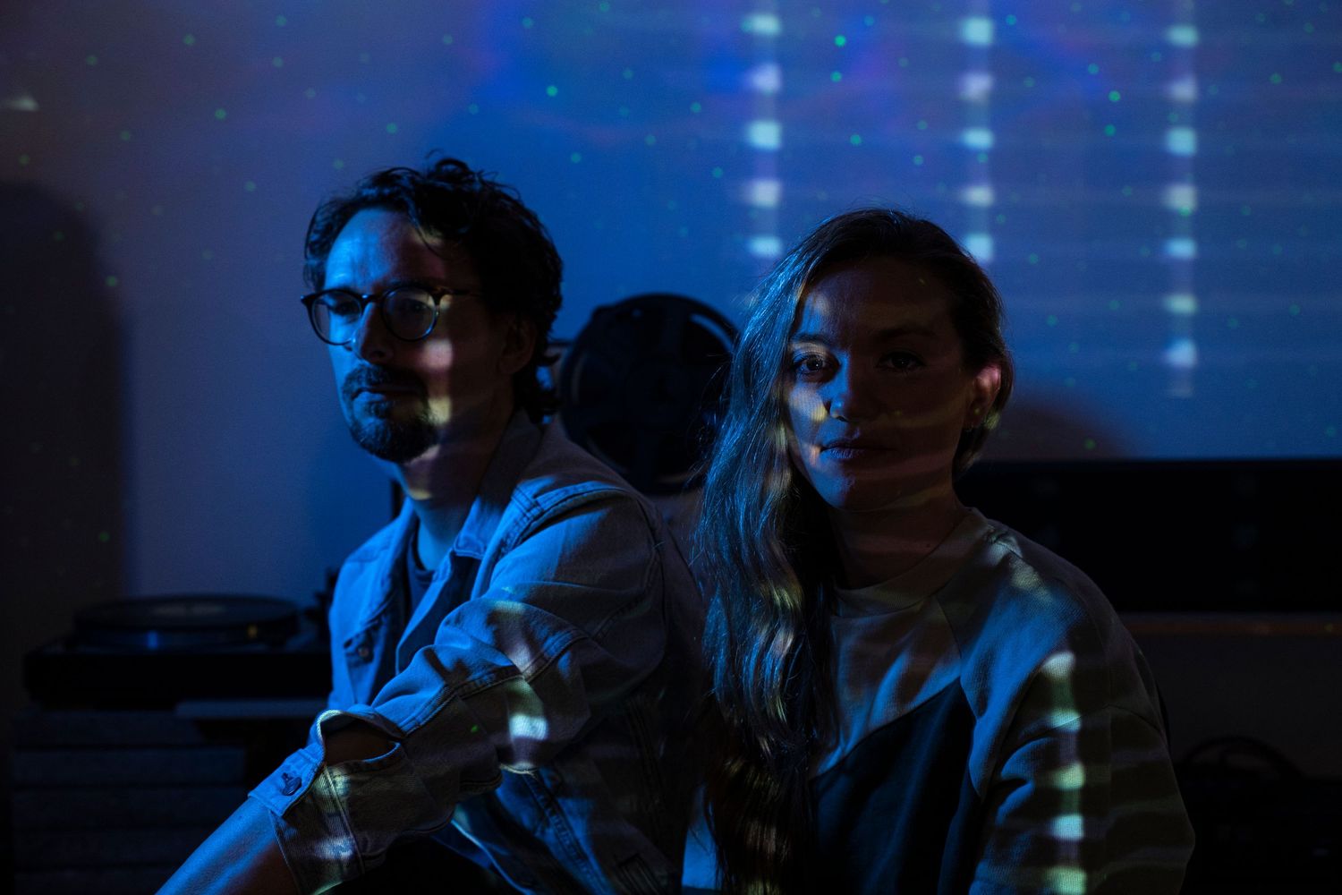 A sequence of silhouettes against a blue-lit background shows people engaged in a performance or presentation.