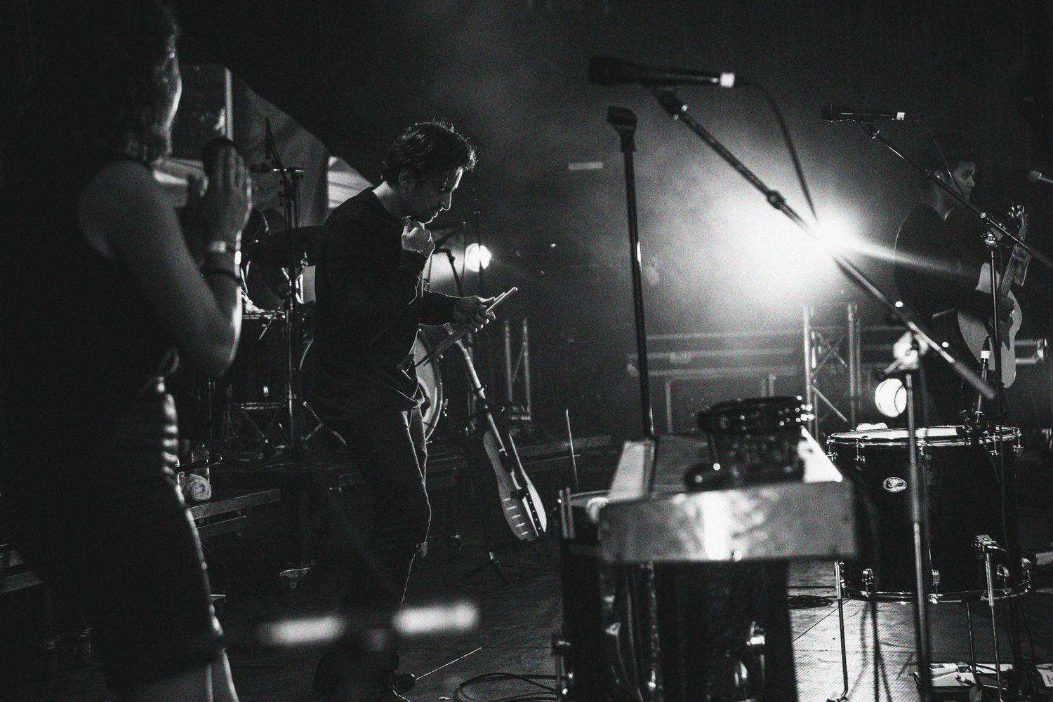 Dramatic black and white concert photos showing musicians performing on stage with dramatic lighting and instruments.