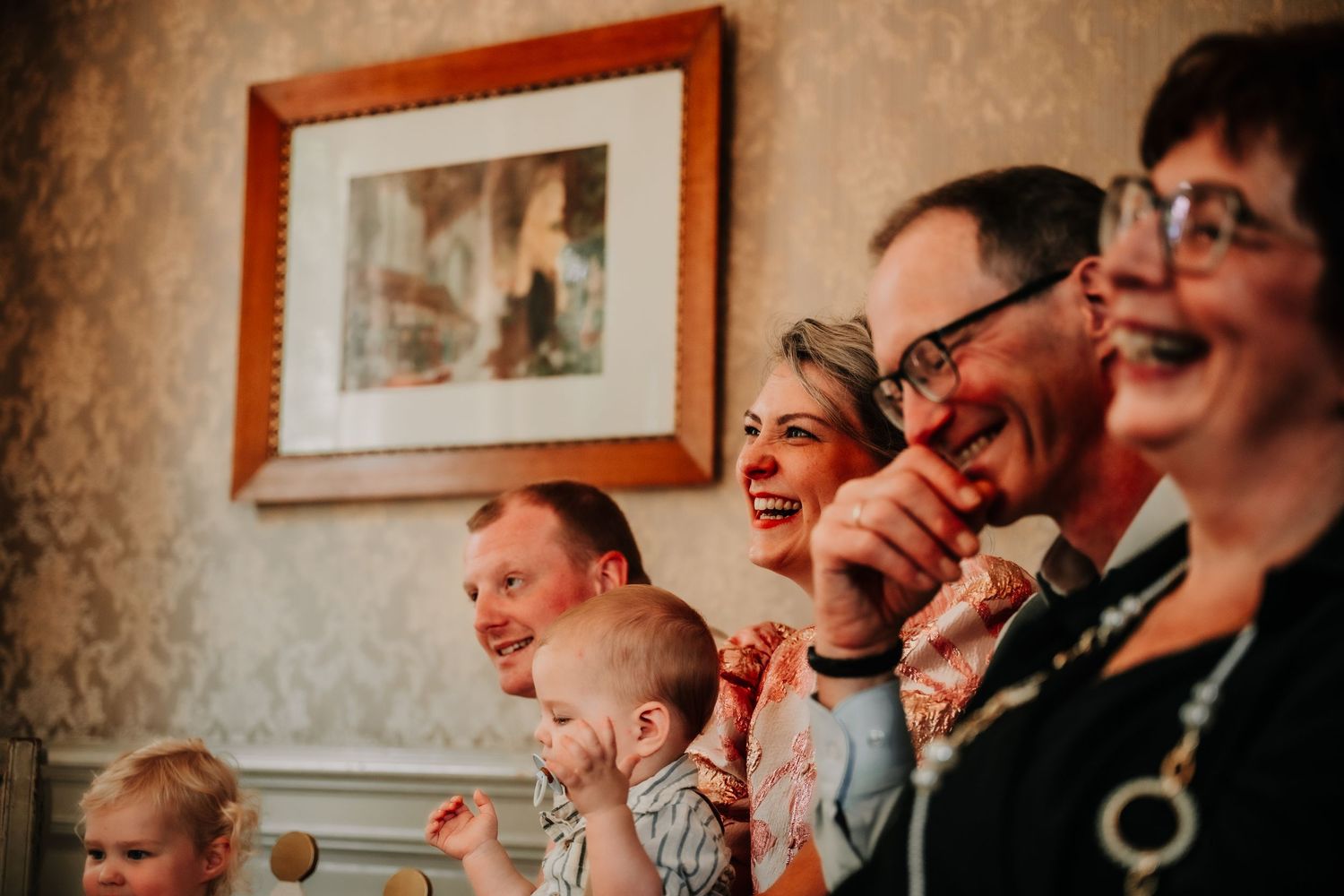 Wedding guests share a joyous moment of laughter during reception festivities.