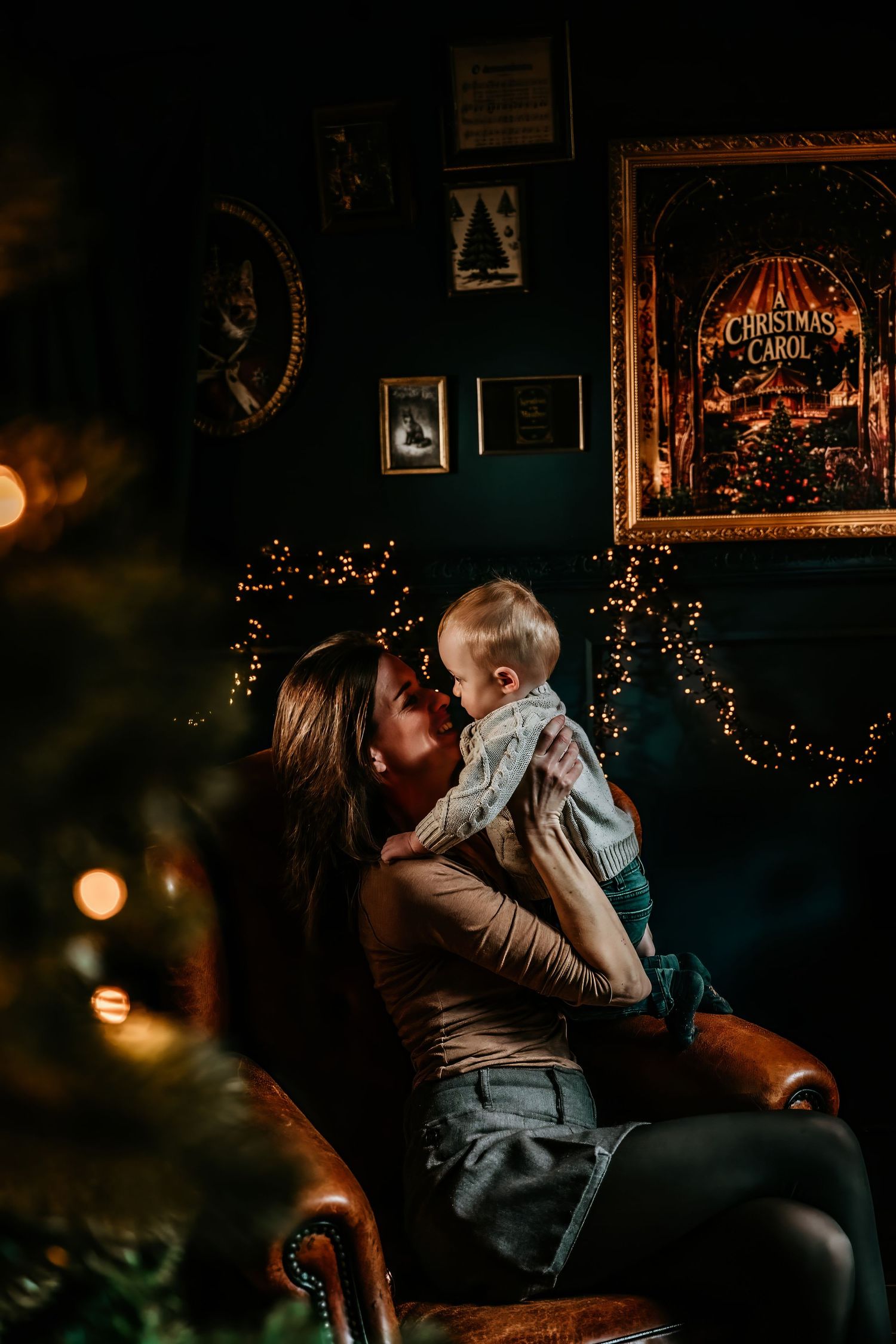A romantic couple shares an intimate moment on a couch in a dimly lit room decorated with Christmas lights.