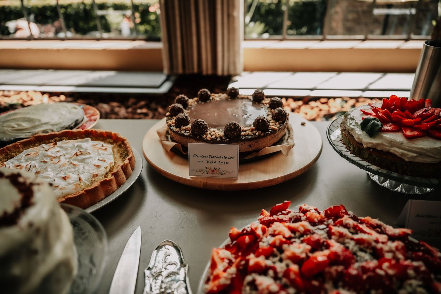 Dessert table spread featuring various cakes and treats decorated with fresh berries.