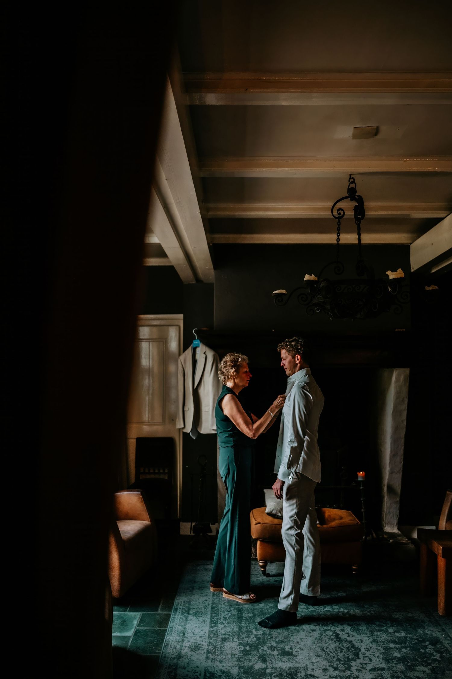A couple shares an intimate moment in a dimly lit room with wooden beams and vintage decor.