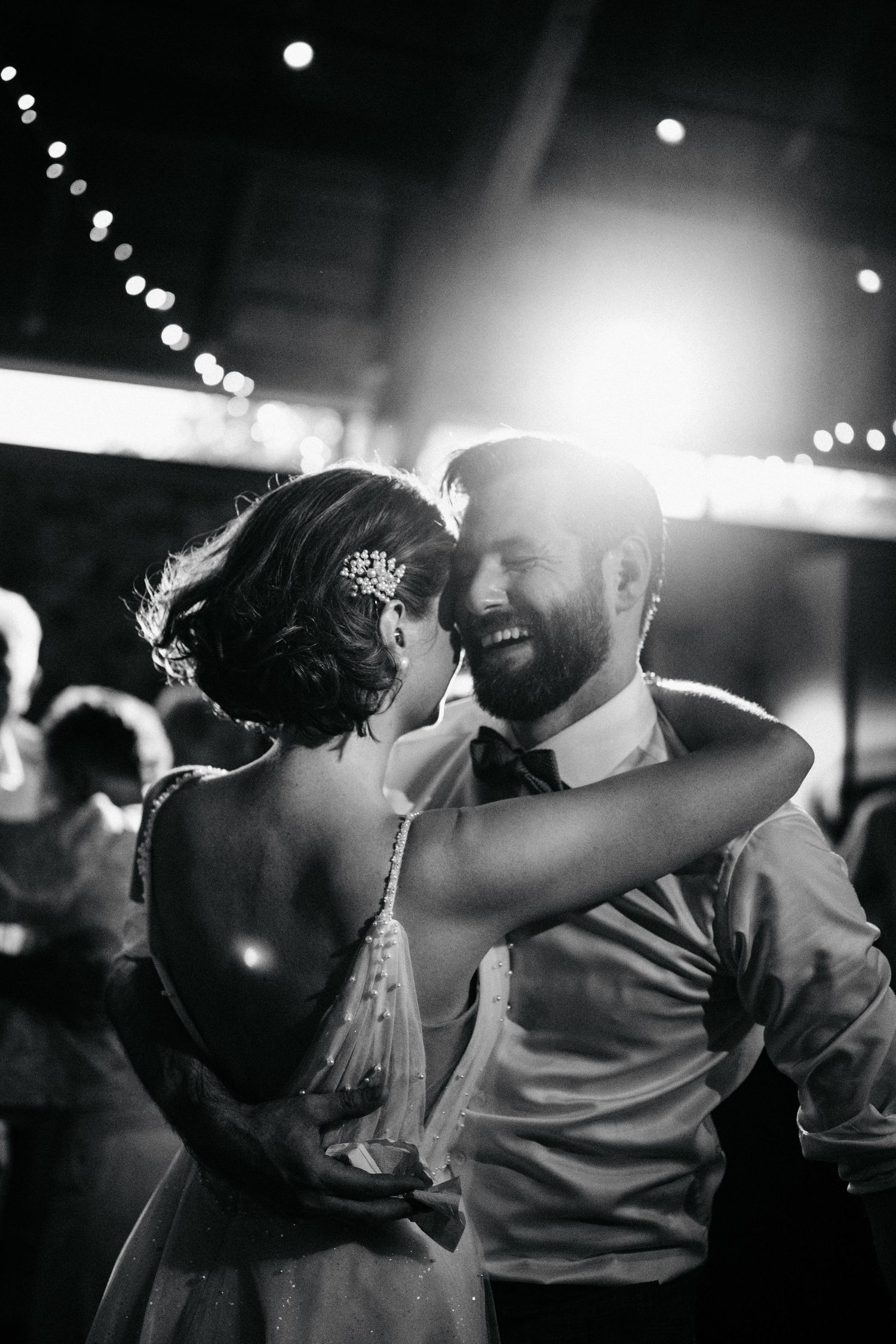 Black and white sequence of a romantic dance moment under string lights.