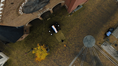 A scenic aerial view of a winding mountain road with autumn trees and sunlight casting long shadows.