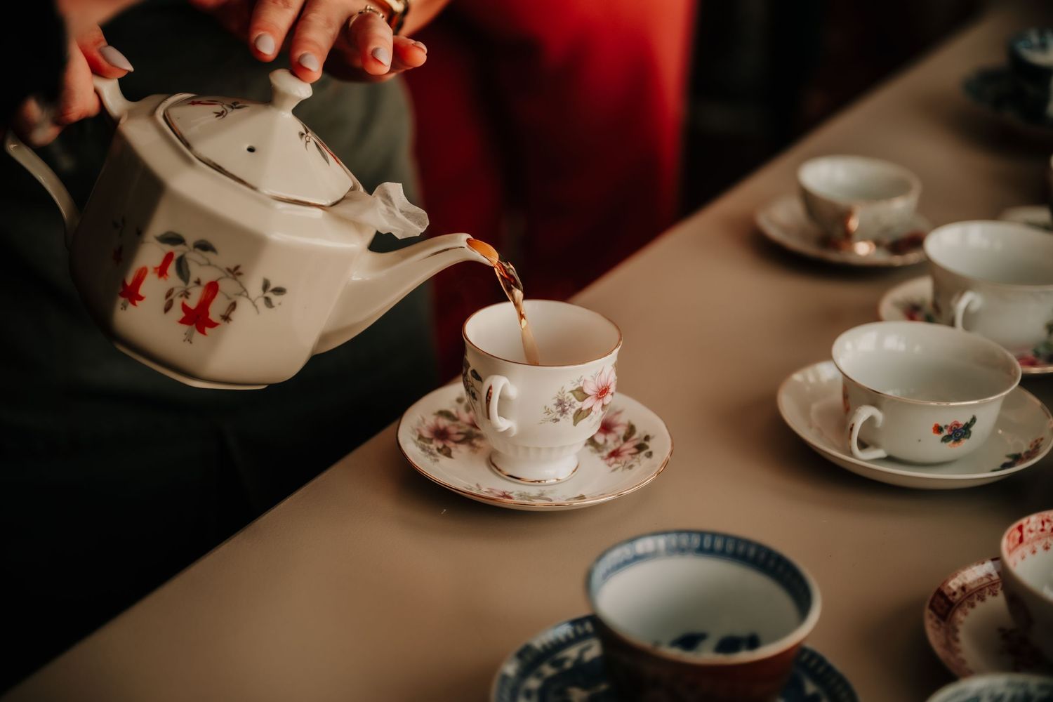 Vintage teacups and saucers with floral patterns arranged on a table.
