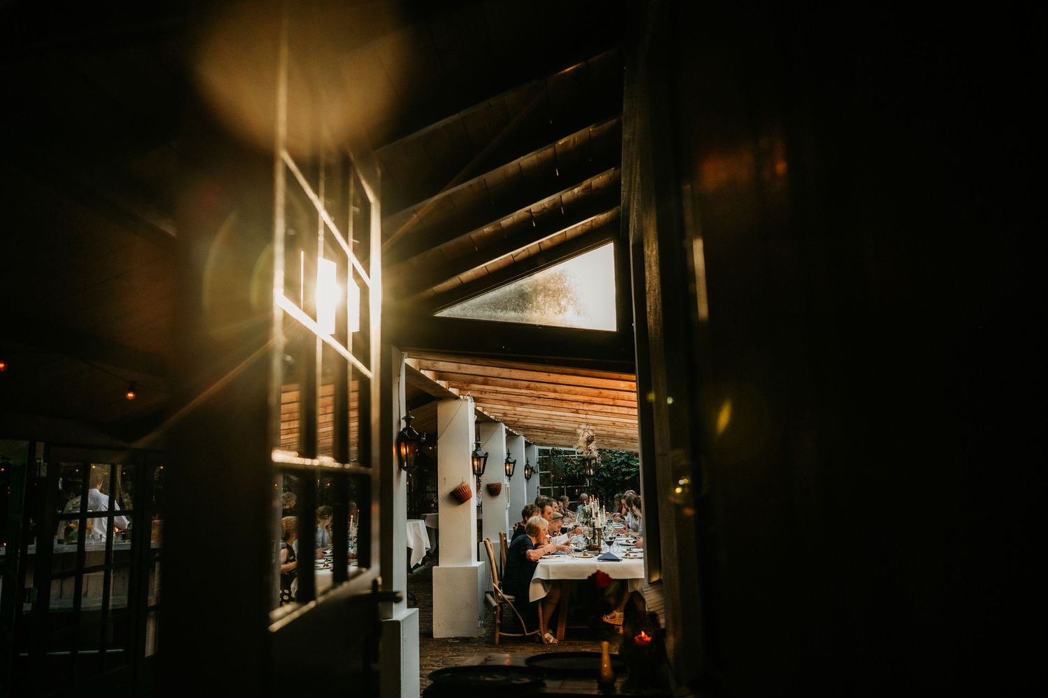 Atmospheric evening view through a doorway into an illuminated reception space.