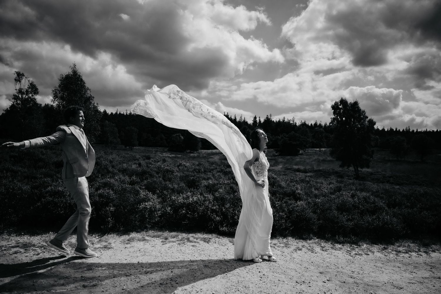 Dramatic black and white wedding photos capture couple dancing in a scenic mountain landscape.