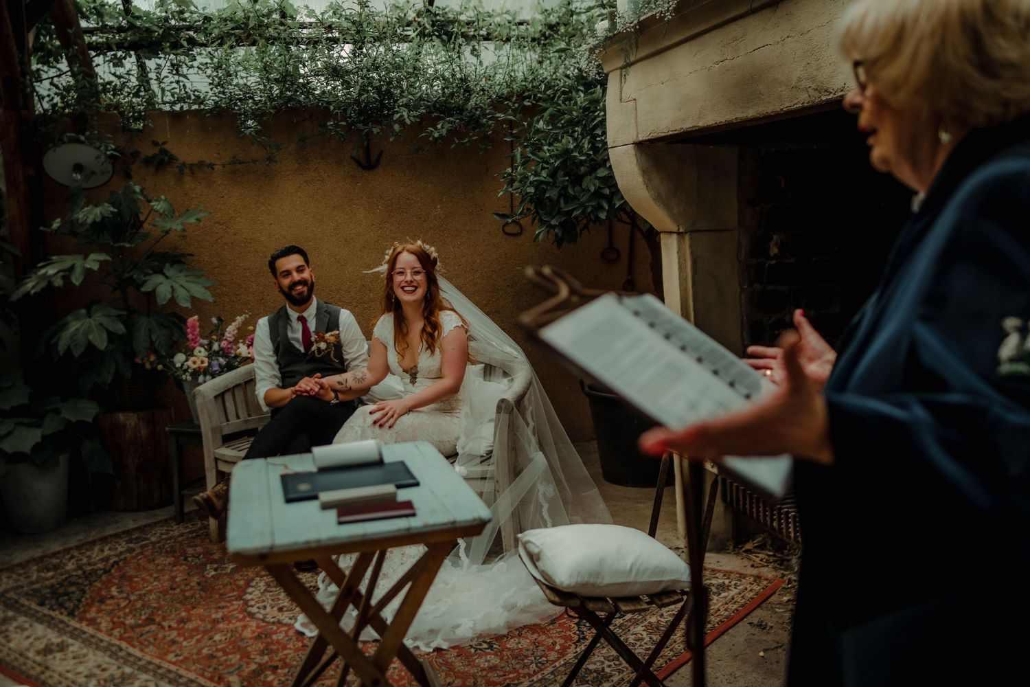 An intimate outdoor wedding ceremony space with rustic wooden chairs and natural greenery.